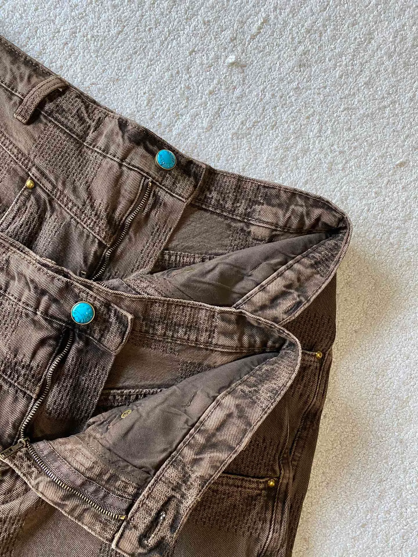 LV brown checkerboard denim straight trousers ⚠️Original purchase, 600, skateboard straight version, Marque L. Uuitton deposee logo integrated into 3D Damier jacquard, back Damier label, sand washed distressed, topstitch sewing, placket distressed hardware closure #Logo integrated into 3D Damier jacquard 3D Damier jacquard denim fabric is an innovative fabric that combines jacquard technology and the characteristics of denim cloth. The classic plaid pattern is combined with 3D jacquard technology to weave three-dimensional patterns on the fabric through a loom.  The fabric presents an exquisite plaid pattern in appearance, and the pattern is made three-dimensional and layered through jacquard technology. At the same time, it retains the original tough, wear-resistant and durable properties of denim, making the clothes more durable.  # Sandwashed, Faded and Distressed Effect Sandwashed, faded and distressed denim fabric is a specially treated denim fabric that exhibits a whitened and distressed effect. This fabric uses a sand-washing process and special dyeing technology to create a natural wear and fading effect on the denim after washing, making it look more vintage and historical.  #skateboard straight jeans version Skateboard jeans are usually designed to be looser to accommodate the large movements and squatting postures during skateboarding. Jeans have a straight shape and a consistent width from hip to hem. Suitable for all body types, these straight-leg skateboard pants are designed with comfort and freedom in mind for skateboarding.
