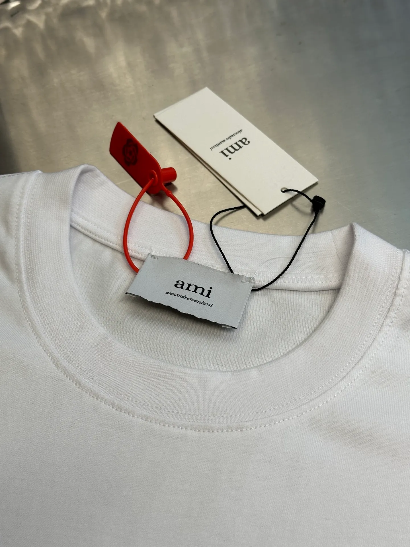 🅿️250 Ami Paris love embossed short-sleeve, custom-made brocade cotton, with a homogeneous three-dimensional love heart on the chest, complementing the AMI embroidery on the back to increase brand recognition. It is the ultimate simplification of color, and it also conveys the love and persistence of life.  High-temperature three-dimensional embossing, through precise control of temperature and pressure, the fiber chains will rearrange to form a three-dimensional concave and convex pattern, showing a unique three-dimensional love effect.  Using imported machine embroidery technology, advanced computer control systems and precision mechanical components are used to realize Ami embroidery operations.  size：s m l xl