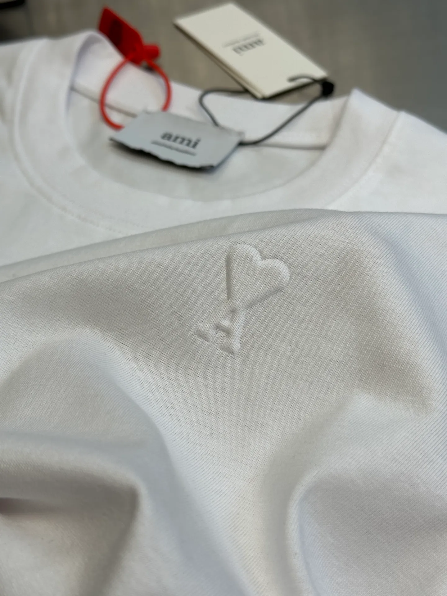 🅿️250 Ami Paris love embossed short-sleeve, custom-made brocade cotton, with a homogeneous three-dimensional love heart on the chest, complementing the AMI embroidery on the back to increase brand recognition. It is the ultimate simplification of color, and it also conveys the love and persistence of life.  High-temperature three-dimensional embossing, through precise control of temperature and pressure, the fiber chains will rearrange to form a three-dimensional concave and convex pattern, showing a unique three-dimensional love effect.  Using imported machine embroidery technology, advanced computer control systems and precision mechanical components are used to realize Ami embroidery operations.  size：s m l xl