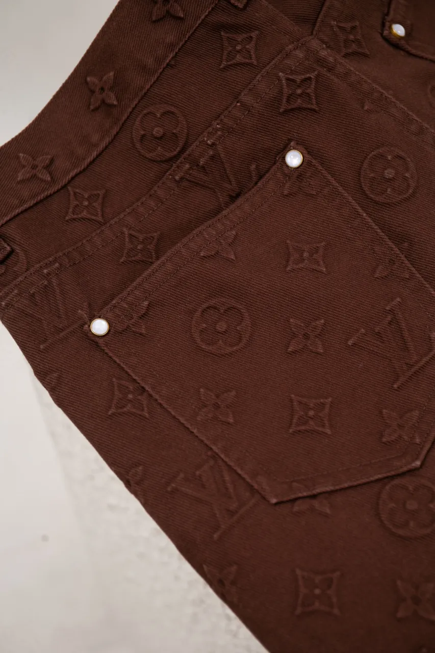The new LV 25ss skateboard pants feature an all-over Monogram embossed pattern, cleverly integrated into the nubuck leather Damier label, pearlescent buttons and rivets, demonstrating Louis Vuitton’s exquisite craftsmanship. The elegant silhouette is dip-dyed in a calm hue that pairs well with the coordinating jacket-style shirt. Number of yards: 29.30.31.32.