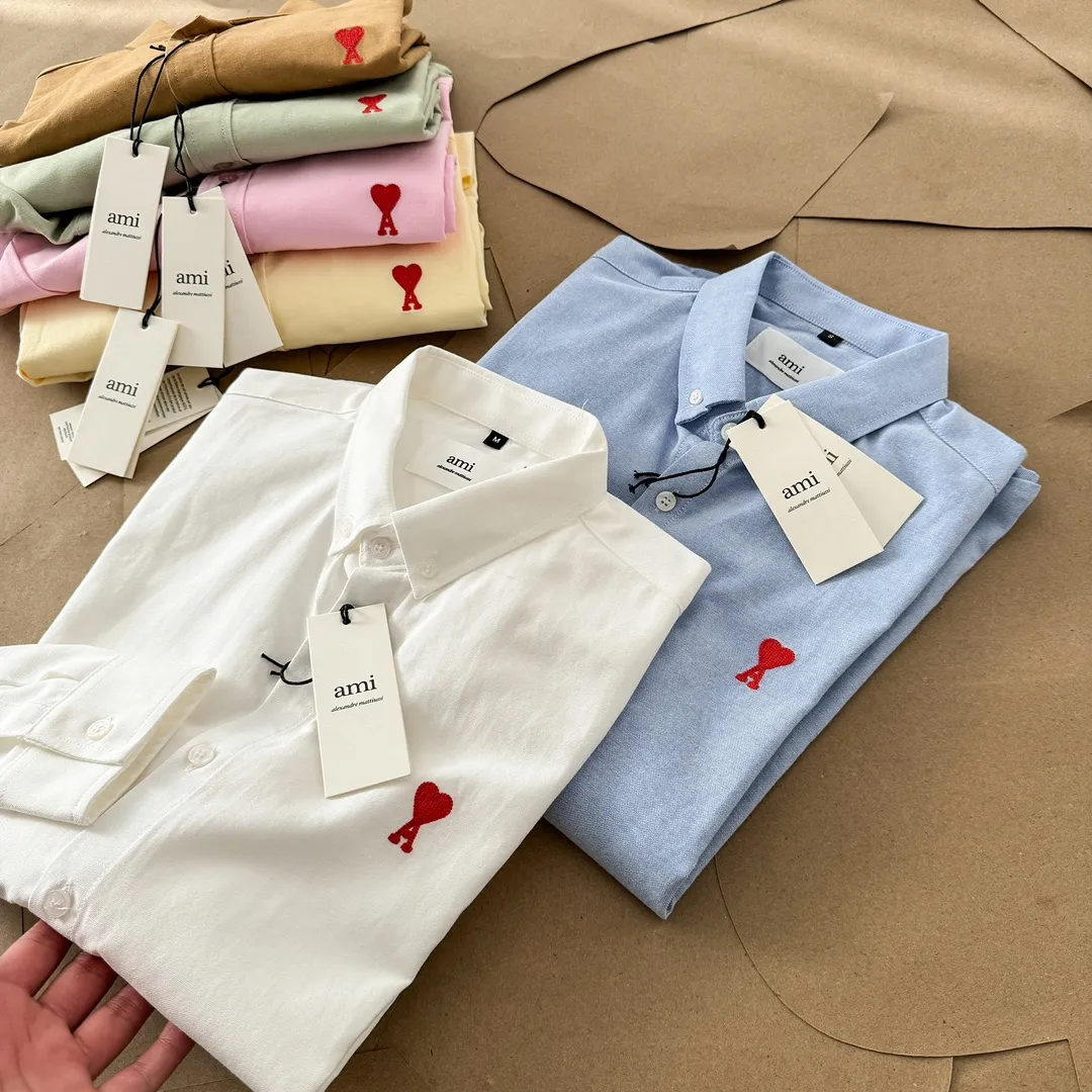 Ami Paris Oxford cotton button-down corner collar casual shirt-small love couple's long-sleeved shirt-same style for men and women. Red small love letter embroidery decoration fashionable and versatile long-sleeved shirt! On sale simultaneously at counters! A well-known French affordable luxury fashion brand. The brand's classic elements are embellishments sought after by major celebrities. Its basic simple design and fashionable style make it a must-have couple's shirt for men and women!  Made of custom-woven 100% Oxford cloth pure cotton, it feels soft and delicate, has excellent moisture absorption and perspiration performance, and is very comfortable and skin-friendly when worn next to the skin! The chest of the shirt is decorated with the classic love letter A logo embroidery. The top-notch embroidery technology is tight, full and full of details, and is cleverly embellished with bright red. It carries all the eye-catching points. It follows the consistent minimalist French attitude. The fabric is soft and comfortable, suitable for any versatile casual shirt couple!  Color: Yellow Pink Green Brown (Loose fit) S-XL is too large White Blue (Standard fit) S-XXL Standard Size: White Blue S-XXL S: Bust 96 Shoulder width 44 Clothing length 68 Sleeve length 58 M: Bust 100 Shoulder width 46 Clothing length 70 Sleeve length 60 L: Bust 104 Shoulder width 48 Clothing length 72 Sleeve length 62 XL: Bust 108, shoulder width 50, dress length 74, sleeve length 63 XXL: Bust 112, shoulder width 52, dress length 76, sleeve length 64 Sizes: Yellow Pink Green Brown S-XL S: Bust 106, shoulder width 47, dress length 71, sleeve length 60 M: Bust 110, shoulder width 48, dress length 73, sleeve length 61 L: Bust 114 Shoulder width 49, clothing length 75, sleeve length 62 XL: Bust 118, shoulder width 50, clothing length 76, sleeve length 63