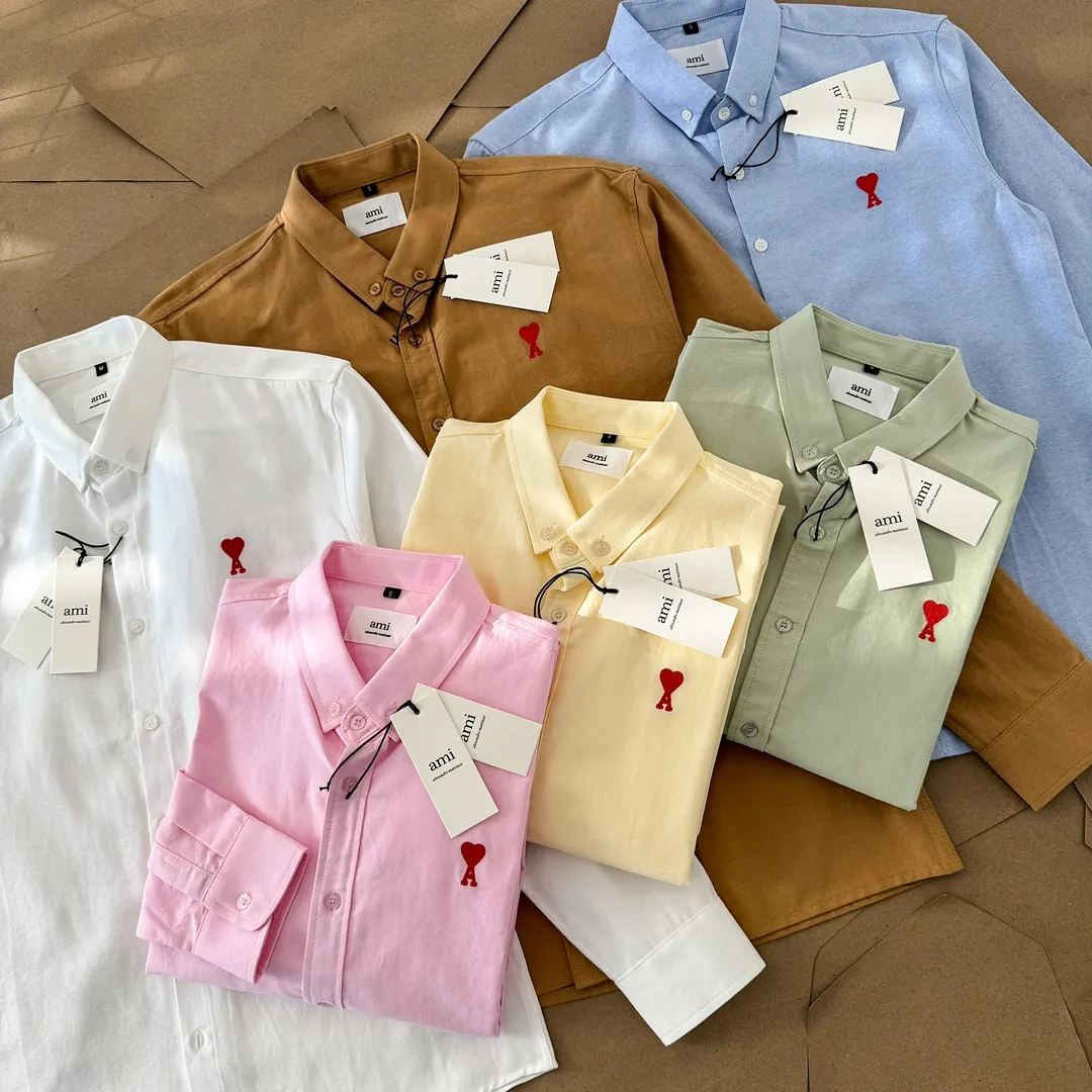 Ami Paris Oxford cotton button-down corner collar casual shirt-small love couple's long-sleeved shirt-same style for men and women. Red small love letter embroidery decoration fashionable and versatile long-sleeved shirt! On sale simultaneously at counters! A well-known French affordable luxury fashion brand. The brand's classic elements are embellishments sought after by major celebrities. Its basic simple design and fashionable style make it a must-have couple's shirt for men and women!  Made of custom-woven 100% Oxford cloth pure cotton, it feels soft and delicate, has excellent moisture absorption and perspiration performance, and is very comfortable and skin-friendly when worn next to the skin! The chest of the shirt is decorated with the classic love letter A logo embroidery. The top-notch embroidery technology is tight, full and full of details, and is cleverly embellished with bright red. It carries all the eye-catching points. It follows the consistent minimalist French attitude. The fabric is soft and comfortable, suitable for any versatile casual shirt couple!  Color: Yellow Pink Green Brown (Loose fit) S-XL is too large White Blue (Standard fit) S-XXL Standard Size: White Blue S-XXL S: Bust 96 Shoulder width 44 Clothing length 68 Sleeve length 58 M: Bust 100 Shoulder width 46 Clothing length 70 Sleeve length 60 L: Bust 104 Shoulder width 48 Clothing length 72 Sleeve length 62 XL: Bust 108, shoulder width 50, dress length 74, sleeve length 63 XXL: Bust 112, shoulder width 52, dress length 76, sleeve length 64 Sizes: Yellow Pink Green Brown S-XL S: Bust 106, shoulder width 47, dress length 71, sleeve length 60 M: Bust 110, shoulder width 48, dress length 73, sleeve length 61 L: Bust 114 Shoulder width 49, clothing length 75, sleeve length 62 XL: Bust 118, shoulder width 50, clothing length 76, sleeve length 63