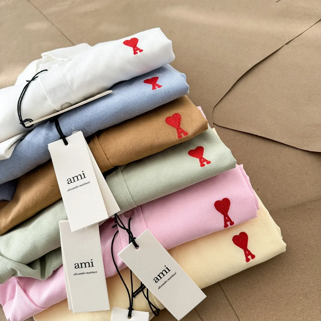 Ami Paris Oxford cotton button-down corner collar casual shirt-small love couple's long-sleeved shirt-same style for men and women. Red small love letter embroidery decoration fashionable and versatile long-sleeved shirt! On sale simultaneously at counters! A well-known French affordable luxury fashion brand. The brand's classic elements are embellishments sought after by major celebrities. Its basic simple design and fashionable style make it a must-have couple's shirt for men and women!  Made of custom-woven 100% Oxford cloth pure cotton, it feels soft and delicate, has excellent moisture absorption and perspiration performance, and is very comfortable and skin-friendly when worn next to the skin! The chest of the shirt is decorated with the classic love letter A logo embroidery. The top-notch embroidery technology is tight, full and full of details, and is cleverly embellished with bright red. It carries all the eye-catching points. It follows the consistent minimalist French attitude. The fabric is soft and comfortable, suitable for any versatile casual shirt couple!  Color: Yellow Pink Green Brown (Loose fit) S-XL is too large White Blue (Standard fit) S-XXL Standard Size: White Blue S-XXL S: Bust 96 Shoulder width 44 Clothing length 68 Sleeve length 58 M: Bust 100 Shoulder width 46 Clothing length 70 Sleeve length 60 L: Bust 104 Shoulder width 48 Clothing length 72 Sleeve length 62 XL: Bust 108, shoulder width 50, dress length 74, sleeve length 63 XXL: Bust 112, shoulder width 52, dress length 76, sleeve length 64 Sizes: Yellow Pink Green Brown S-XL S: Bust 106, shoulder width 47, dress length 71, sleeve length 60 M: Bust 110, shoulder width 48, dress length 73, sleeve length 61 L: Bust 114 Shoulder width 49, clothing length 75, sleeve length 62 XL: Bust 118, shoulder width 50, clothing length 76, sleeve length 63