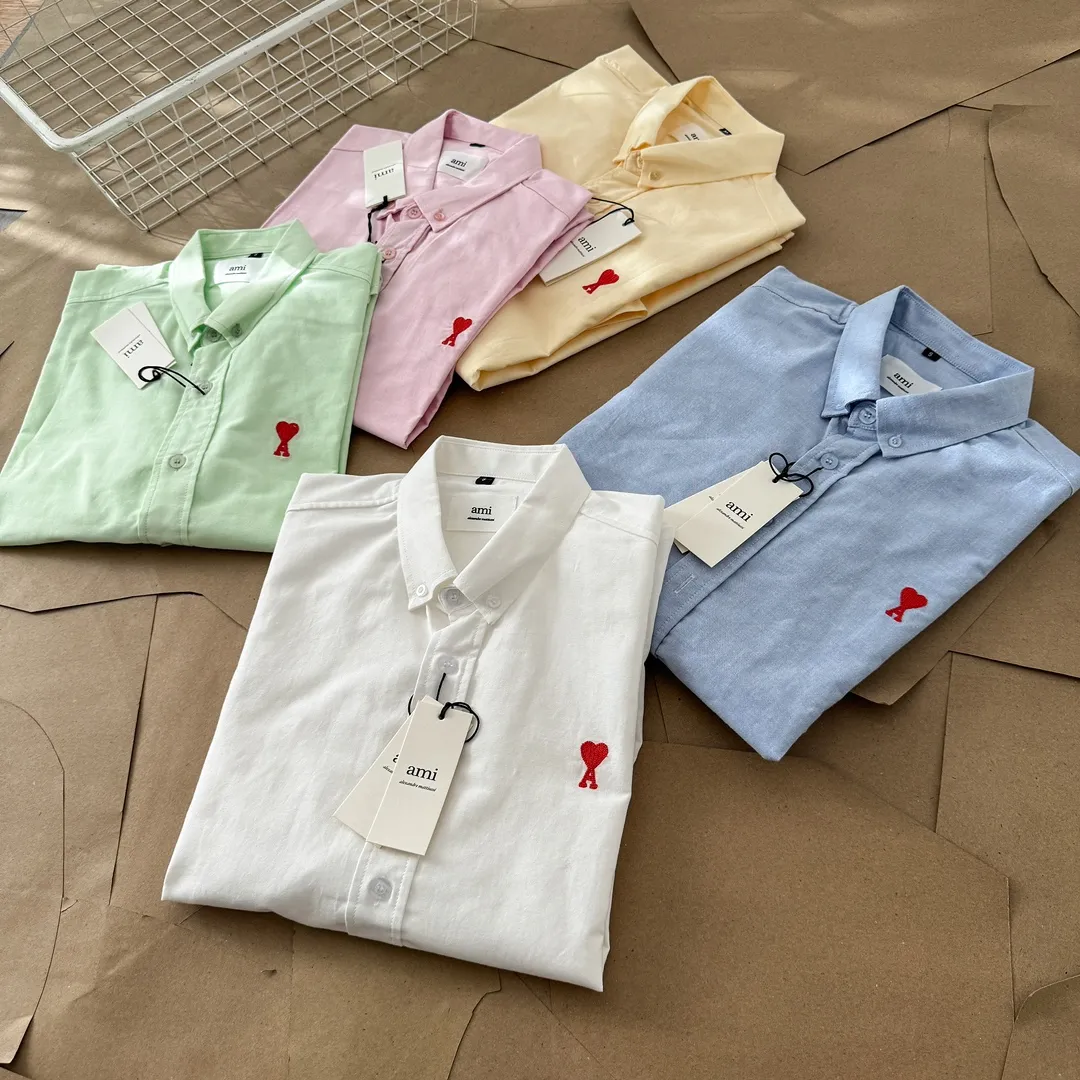 Ami Paris Oxford cotton button-down corner collar casual short-sleeved shirt - small love silhouette style - same style for men and women. Red small love letter embroidery decoration, fashionable and versatile short-sleeved shirt! The counter sells famous French affordable luxury fashion brands at the same time. The classic elements of the brand are popular among celebrities. The basic simple design and fashionable style are must-have couple shirts for men and women!  Made of custom-woven 100% Oxford cloth pure cotton, it feels soft and delicate, has excellent moisture absorption and perspiration performance, and is very comfortable and skin-friendly when worn next to the skin! The chest of the shirt is decorated with the classic love letter A logo embroidery. The top-notch embroidery technology is tight, full and full of details, and is cleverly embellished with bright red. It carries all the eye-catching points. It follows the consistent minimalist French attitude. The fabric is soft and comfortable, suitable for any versatile casual shirt couple!  Color: Blue White Yellow Green Pink Size: S-XL Size: Size Length Bust Shoulder Width Sleeve Length S 73.5 68 56 26.5 M 75.5 70 57 27 L 77.5 72 58 27.5 XL 79.5 74 59 28