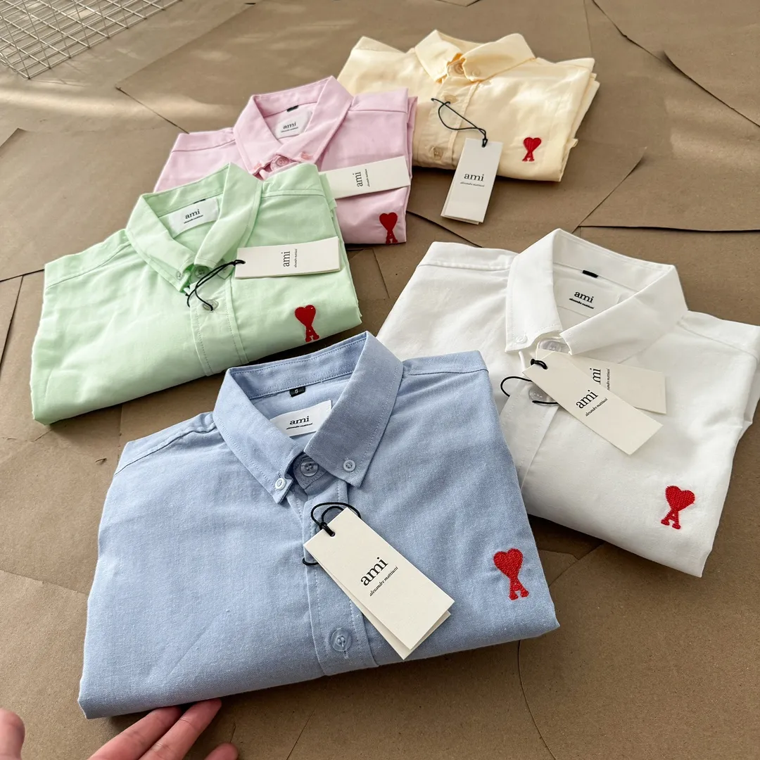Ami Paris Oxford cotton button-down corner collar casual short-sleeved shirt - small love silhouette style - same style for men and women. Red small love letter embroidery decoration, fashionable and versatile short-sleeved shirt! The counter sells famous French affordable luxury fashion brands at the same time. The classic elements of the brand are popular among celebrities. The basic simple design and fashionable style are must-have couple shirts for men and women!  Made of custom-woven 100% Oxford cloth pure cotton, it feels soft and delicate, has excellent moisture absorption and perspiration performance, and is very comfortable and skin-friendly when worn next to the skin! The chest of the shirt is decorated with the classic love letter A logo embroidery. The top-notch embroidery technology is tight, full and full of details, and is cleverly embellished with bright red. It carries all the eye-catching points. It follows the consistent minimalist French attitude. The fabric is soft and comfortable, suitable for any versatile casual shirt couple!  Color: Blue White Yellow Green Pink Size: S-XL Size: Size Length Bust Shoulder Width Sleeve Length S 73.5 68 56 26.5 M 75.5 70 57 27 L 77.5 72 58 27.5 XL 79.5 74 59 28