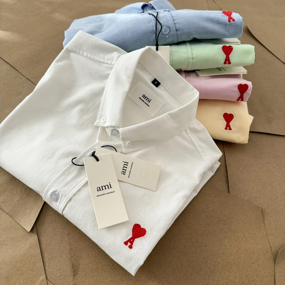 Ami Paris Oxford cotton button-down corner collar casual short-sleeved shirt - small love silhouette style - same style for men and women. Red small love letter embroidery decoration, fashionable and versatile short-sleeved shirt! The counter sells famous French affordable luxury fashion brands at the same time. The classic elements of the brand are popular among celebrities. The basic simple design and fashionable style are must-have couple shirts for men and women!  Made of custom-woven 100% Oxford cloth pure cotton, it feels soft and delicate, has excellent moisture absorption and perspiration performance, and is very comfortable and skin-friendly when worn next to the skin! The chest of the shirt is decorated with the classic love letter A logo embroidery. The top-notch embroidery technology is tight, full and full of details, and is cleverly embellished with bright red. It carries all the eye-catching points. It follows the consistent minimalist French attitude. The fabric is soft and comfortable, suitable for any versatile casual shirt couple!  Color: Blue White Yellow Green Pink Size: S-XL Size: Size Length Bust Shoulder Width Sleeve Length S 73.5 68 56 26.5 M 75.5 70 57 27 L 77.5 72 58 27.5 XL 79.5 74 59 28