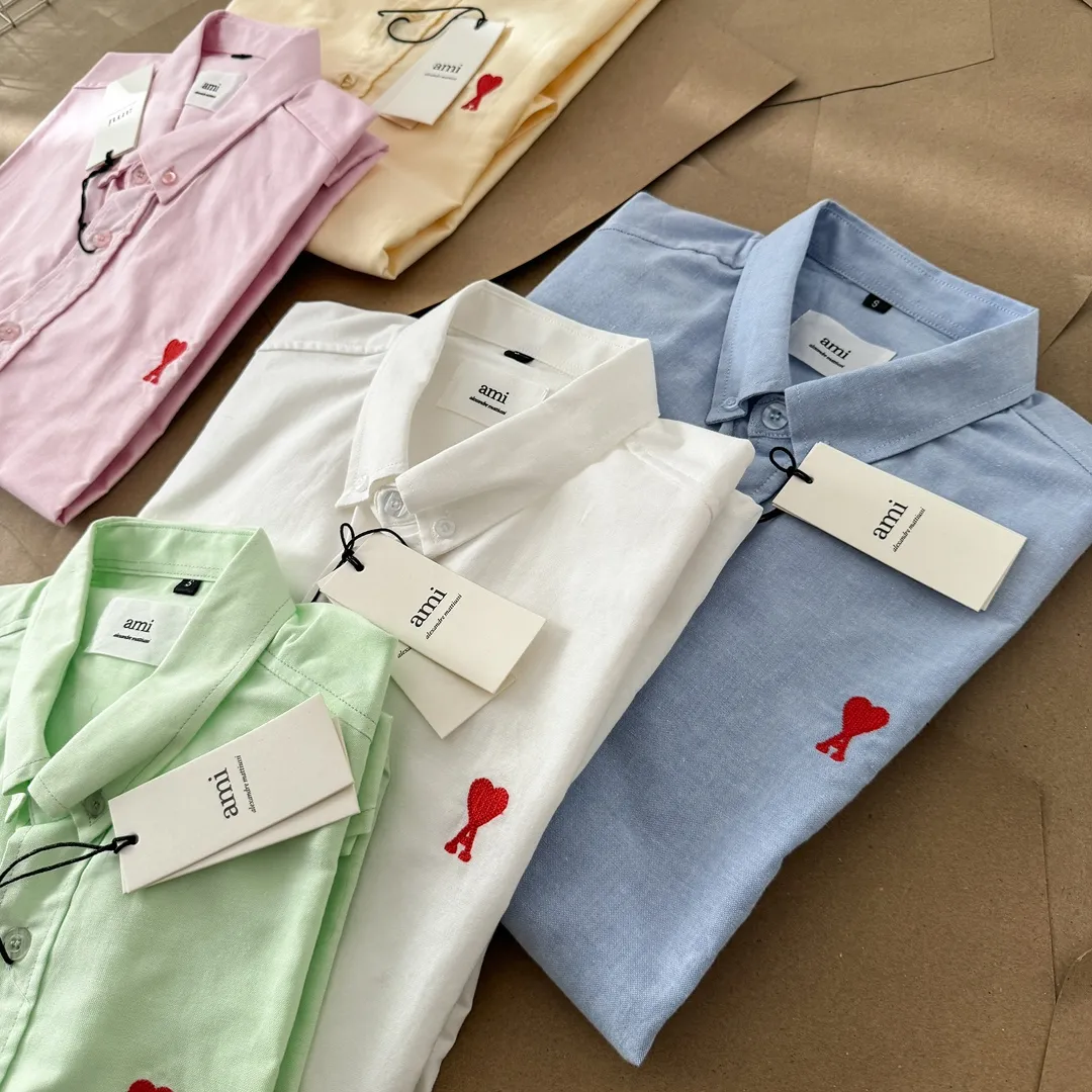 Ami Paris Oxford cotton button-down corner collar casual short-sleeved shirt - small love silhouette style - same style for men and women. Red small love letter embroidery decoration, fashionable and versatile short-sleeved shirt! The counter sells famous French affordable luxury fashion brands at the same time. The classic elements of the brand are popular among celebrities. The basic simple design and fashionable style are must-have couple shirts for men and women!  Made of custom-woven 100% Oxford cloth pure cotton, it feels soft and delicate, has excellent moisture absorption and perspiration performance, and is very comfortable and skin-friendly when worn next to the skin! The chest of the shirt is decorated with the classic love letter A logo embroidery. The top-notch embroidery technology is tight, full and full of details, and is cleverly embellished with bright red. It carries all the eye-catching points. It follows the consistent minimalist French attitude. The fabric is soft and comfortable, suitable for any versatile casual shirt couple!  Color: Blue White Yellow Green Pink Size: S-XL Size: Size Length Bust Shoulder Width Sleeve Length S 73.5 68 56 26.5 M 75.5 70 57 27 L 77.5 72 58 27.5 XL 79.5 74 59 28