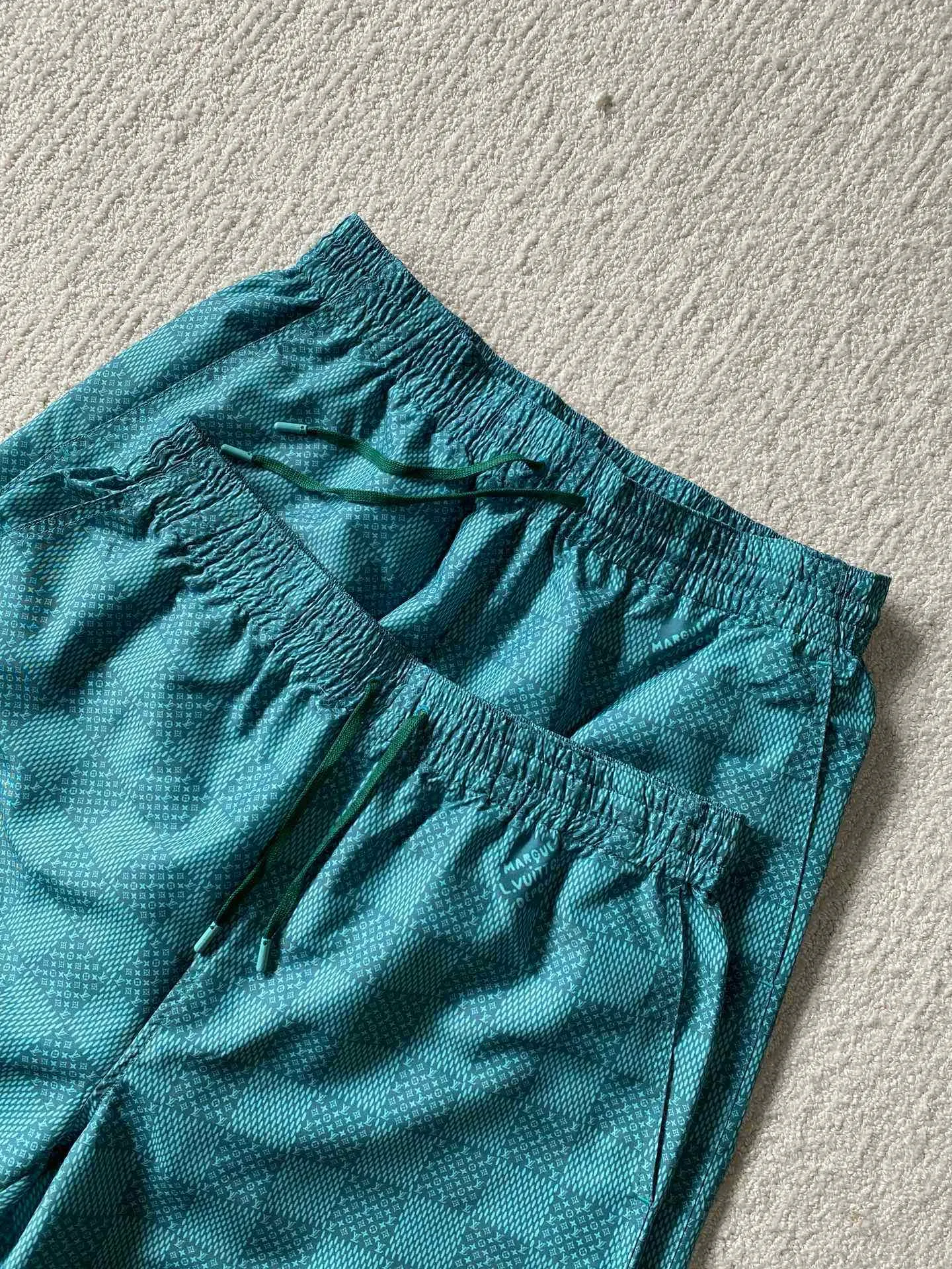 LU green checkerboard beach shorts ⚠️Original purchase, 700, polyester fiber fabric, imported digital printing, cut-piece printing design, standard fit, full-width Damier Monogram printing, drawstring elastic waist #Polyester fiber gray fabric Polyester fiber fabric has excellent wrinkle resistance and shape retention, which allows the shorts to maintain a good appearance after wearing and washing. At the same time, its high strength and good elastic recovery ability ensure the durability of the shorts.  The fabric is very thin and lighter than cotton fiber, so it is very comfortable to wear without feeling tight or compressive. It also has good softness and smooth touch, which increases the wearing comfort.  #Full-width Damier Monogram printing After the entire pattern is processed by image software, the computer control system sprays the printing ink directly onto the fabric through the nozzle of the inkjet printer as required to form the pattern. It is a precise printing controlled by a computer. The digital image is extremely precise. After the digital image is formed, the image is adjusted and printed. After adjusting the image, inkjet printing is performed on a digital printing machine. The ink is directly printed on the surface of the fabric, and the fabric surface penetrates to restore the quality of the original double-sided printing.  #Cut and sew the pattern to restore the original pattern effect. The pattern design is divided into multiple pieces and spliced ​​together, and it also changes due to size changes; even if it is the original version, the splices cannot be perfectly connected. Pieces can only be cut on the same horizontal line, and the patterns on the left and right trouser legs, and the front and rear panels of the entire piece should be arranged on the same horizontal line as much as possible, so that the sewing effect is consistent.  #straight sports shorts version. Fully elastic high waist with adjustable waist size. The front end of the elastic waist rope has an engraved hardware clock. The inner elastic band at the waist is fixed to the outer material through multiple routings, so the elastic band will not flip over even when worn or washed. The zipper pockets are designed with diagonal inserts on both sides; both ends of the pocket are specially machine-knotted, making it strong, durable and washable.