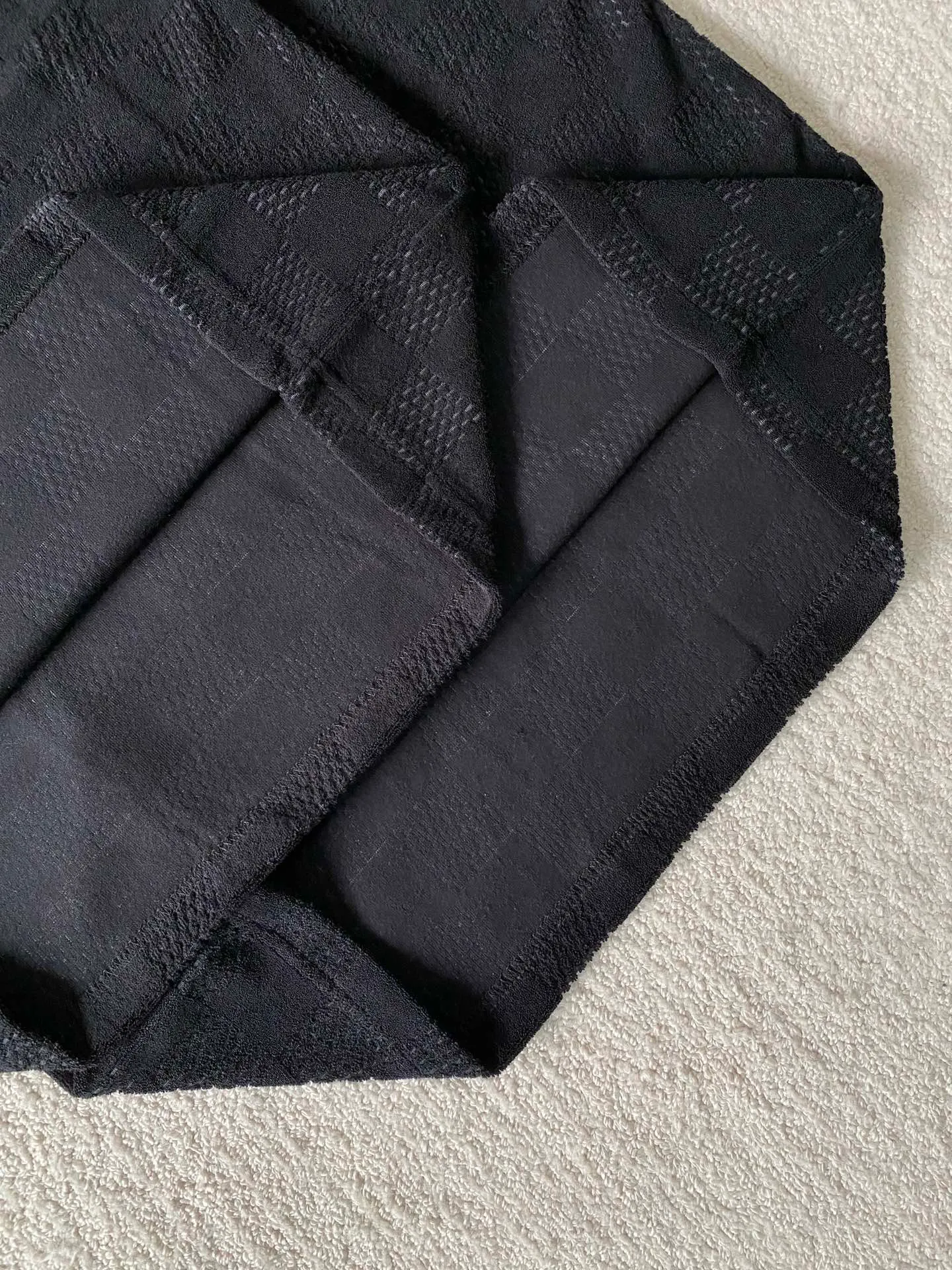 LV towel plaid round neck short sleeves ⚠️Original purchase, 650, standard fit, Damier terry cloth, embroidered Marque L.Uuitton deposee logo on the chest, ribbed collar, floral stitching, full set of accessories with #Damier terry cloth Towel jacquard fabric terry cloth is a fabric that looks like a towel. It has the advantages of high water absorption, good warmth retention, soft hand feel, stiff fabric, and not easy to deform, so it is called terry cloth.  During the weaving process of the full-width embossed pattern, computer digital programming is used to make the plate. The jacquard part has a concave and convex feel, the fabric has a soft and waxy feel, and the fabric details are delicate. The thermal conductivity of towel fabric is low, and because the cotton fiber itself is porous and elastic, a large amount of air can accumulate between the fibers, so the towel fabric has good moisture retention.  #Chest Marque L Uuitton deposee embroidery The chest is embellished with simple letter patterns, and the letter size spacing effect is consistent. Using linen embroidery thread combined with encrypted processing, the embroidery body has a subtle matte visual texture; the embroidery effect is three-dimensional and full. The smaller the embroidery, the more sophisticated and demanding it is. The embroidery thread is made of imported material, which is more flexible and glossy than ordinary embroidery thread; the stitches are clear and smooth, and have a three-dimensional texture effect.  #Positioning Pattern Cutting and Sewing The whole piece positioning pattern sewing process is a fine and complex technology. During the cutting process, it is necessary to ensure that the pattern or texture of each piece can perfectly match other pieces. Through floral tailoring, the checkerboard pattern of ready-made garments appears neatly arranged.  #straight round neck version. Cut and sewed in floral position, standard H hanging version, with shoulder-length design. The vertical version emphasizes that the width of the shoulders, waist, and hem are basically the same, and it is simple and loose. The short sleeves are tailored to fit the body of the wearer. At the same time, the neckline, cuffs and hem of the short sleeves are all designed with double lines.