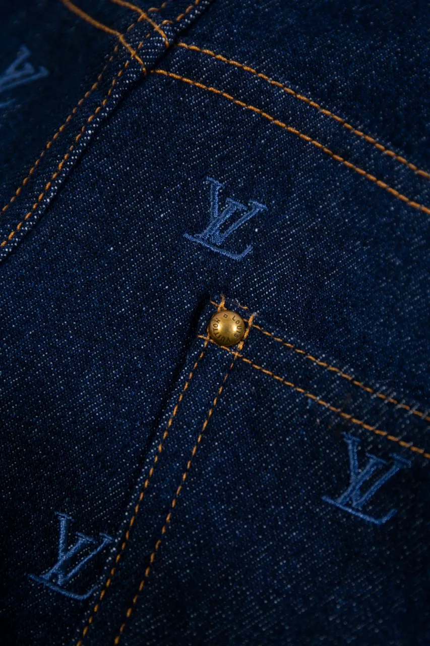 LV Embroidered Jeans This pair of jeans is made of original washed denim, with an all-over LV Blason pattern embroidered with fine yarn. The classic silhouette is finished with a Damier nubuck label and LV metallic accents, making it a sophisticated addition to the matching jacket.  Standard fit All-over LV Blason embroidered Damier nubuck label with LV metallic accents