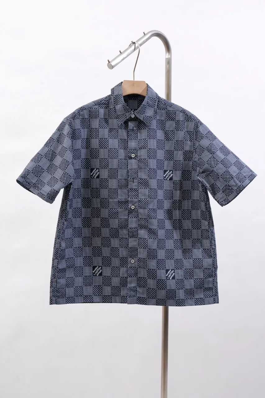 The new LV 24ss short-sleeved shirt is made of lightweight cotton with a full-length Damier Monogram pattern, integrating pocket Monogram elements and the chic Marque L.Vuitton Déposée logo into a checkered pattern. It adds eye-catching style to casual looks and pairs well with the matching beach shorts. Same style for men and women Size: S.M.L.XL