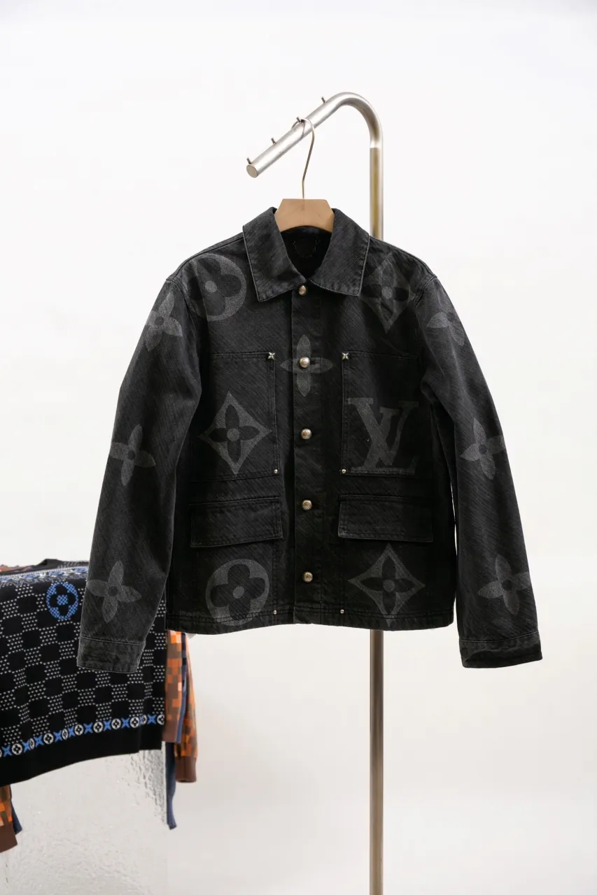 LV MONOGRAM Denim Tunic Jacket Denim Jacket This belted jacket incorporates multiple logo elements into the workwear silhouette, demonstrating the brand's exquisite craftsmanship. The washed denim fabric has a diagonal Epi jacquard texture, and the Monogram Macro pattern with light and dark gradients is superimposed on it. Monogram floral studs add an elegant touch to the design, perfect for matching trousers.  Regular fit Biased Epi jacquard Monogram Macro logo print Rear Damier nubuck patch with metallic LV accents Top pocket with Monogram floral studs Chest patch pocket Front flap pocket
