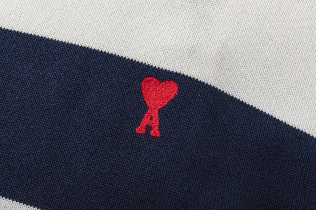 P170 A069# AMI Paris2023 new product. Carefully woven with cotton and wool blended yarn. It has dropped shoulder sleeves and a classic round neck. The blue and white striped body is simple and eye-catching. The red embroidery on the chest easily illustrates the brand identity. Same style for men and women. Color: Black and White, Orchid and White. Size: S-XL.