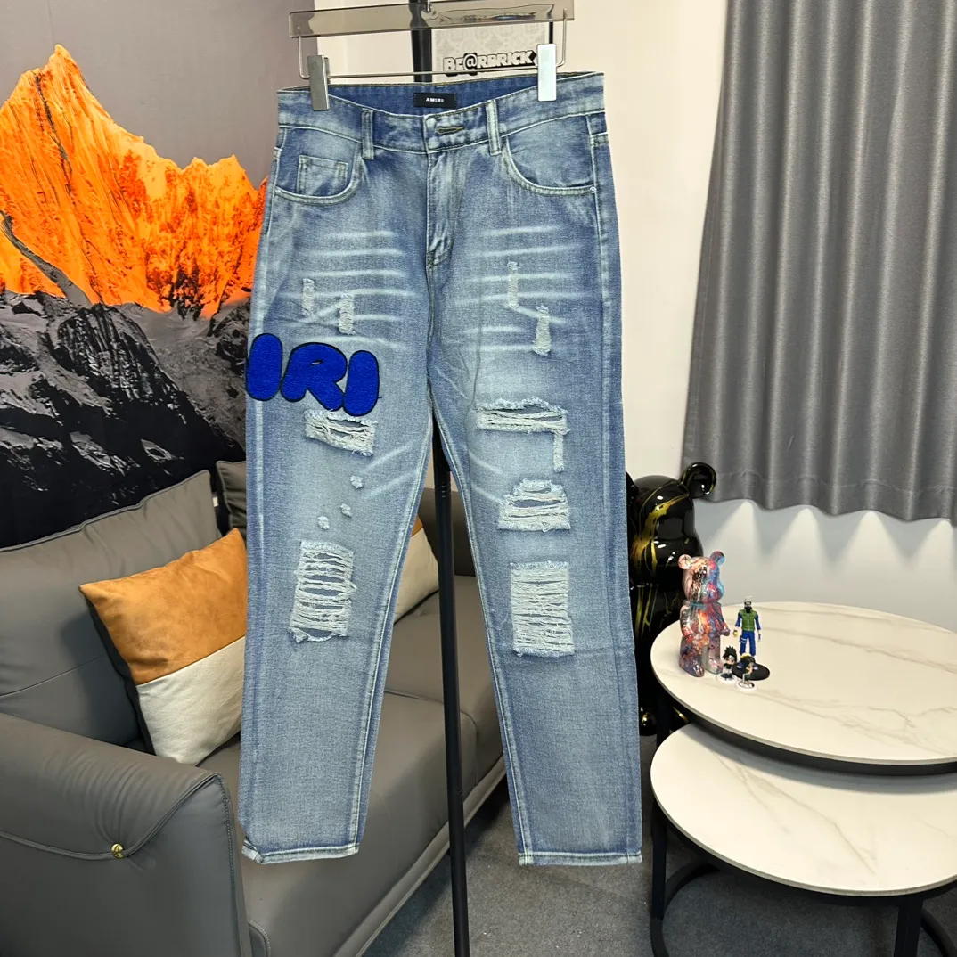 P210 Amiri classic embroidered patched leather distressed letter jeans, slim fit jeans, produced by a major washed factory. Full of high-end feel. Partial damage to the knees and patchwork leather design. Already used as a facade design. Leather waist nameplate. The focus of this style is not on washing, but on the shape and version of the damage. The secret lies in the craftsmanship of the master. Later fraying, horse cutting, knife cutting, etc. The cost of hand-made products is far beyond comparison with assembly line products. Size: 30-32-34-36
