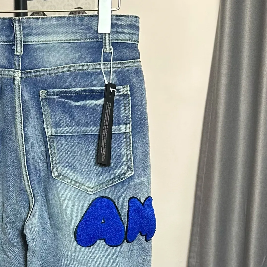 P210 Amiri classic embroidered patched leather distressed letter jeans, slim fit jeans, produced by a major washed factory. Full of high-end feel. Partial damage to the knees and patchwork leather design. Already used as a facade design. Leather waist nameplate. The focus of this style is not on washing, but on the shape and version of the damage. The secret lies in the craftsmanship of the master. Later fraying, horse cutting, knife cutting, etc. The cost of hand-made products is far beyond comparison with assembly line products. Size: 30-32-34-36