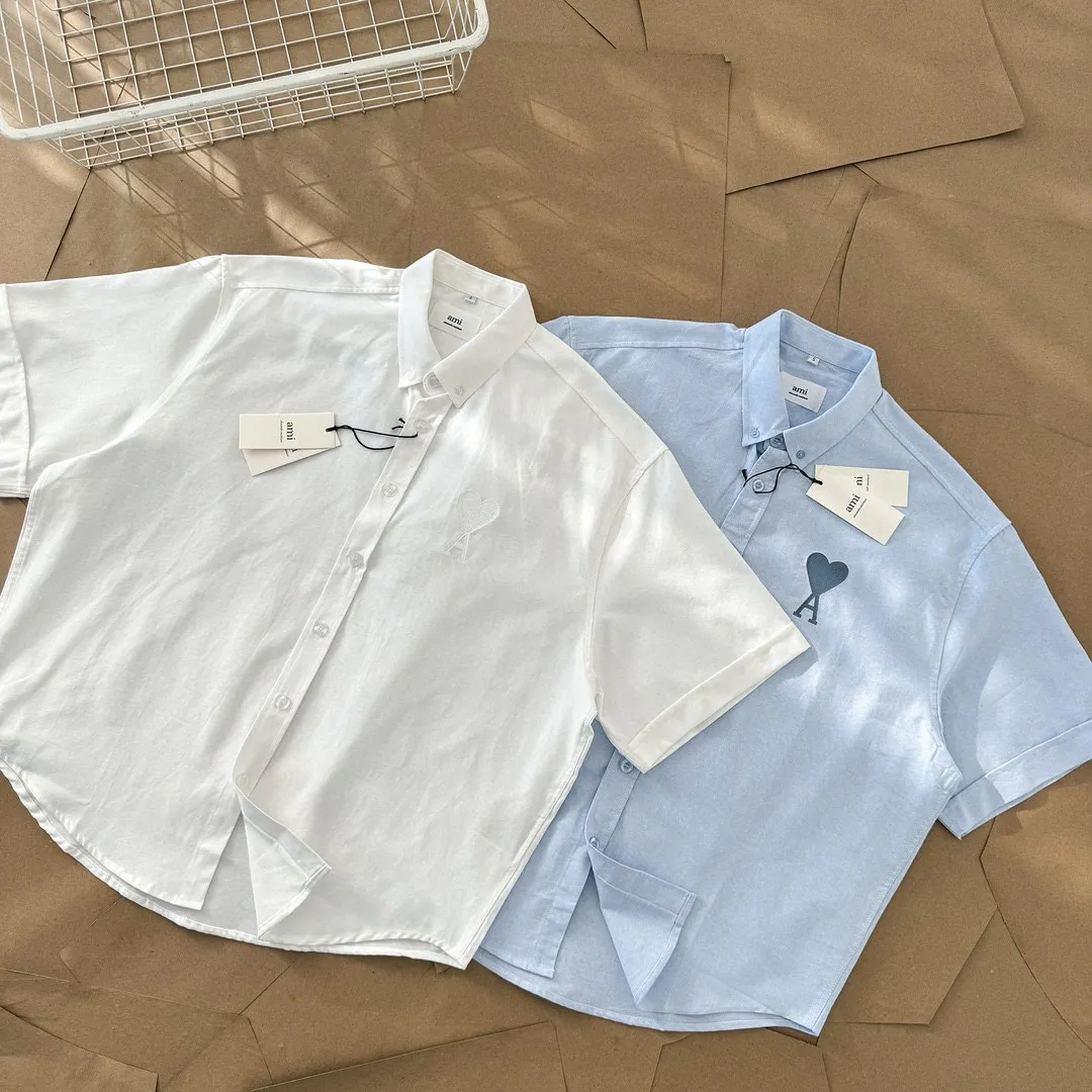 Ami Paris Oxford cotton button-down corner collar casual short-sleeved shirt - big heart style - same style for men and women. Fashionable and versatile short-sleeved shirt with big heart letter embroidery decoration in the same color! Simultaneous sales at counters. A famous French affordable luxury fashion brand. Major stars are looking for the brand's classic element embellishments. The basic simple design is fashionable. It is a must-have couple's shirt for men and women!  Made of custom-woven 100% Oxford cloth pure cotton, it feels soft and delicate, has excellent moisture absorption and perspiration performance, and is very comfortable and skin-friendly when worn next to the skin! The chest of the shirt is decorated with the classic love letter A logo embroidery. The top-notch embroidery technology is tight, full and full of details, and is cleverly embellished with bright red. It carries all the eye-catching points. It follows the consistent minimalist French attitude. The fabric is soft and comfortable, suitable for any versatile casual shirt couple!  Color: Blue White Size: S-XL S: Bust 102, Shoulder 47, Length 70 M: Bust 106, Shoulder 48, Length 72 L: Bust 110, Shoulder 49, Length 74 XL: Bust 114, Shoulder 50, Length 76