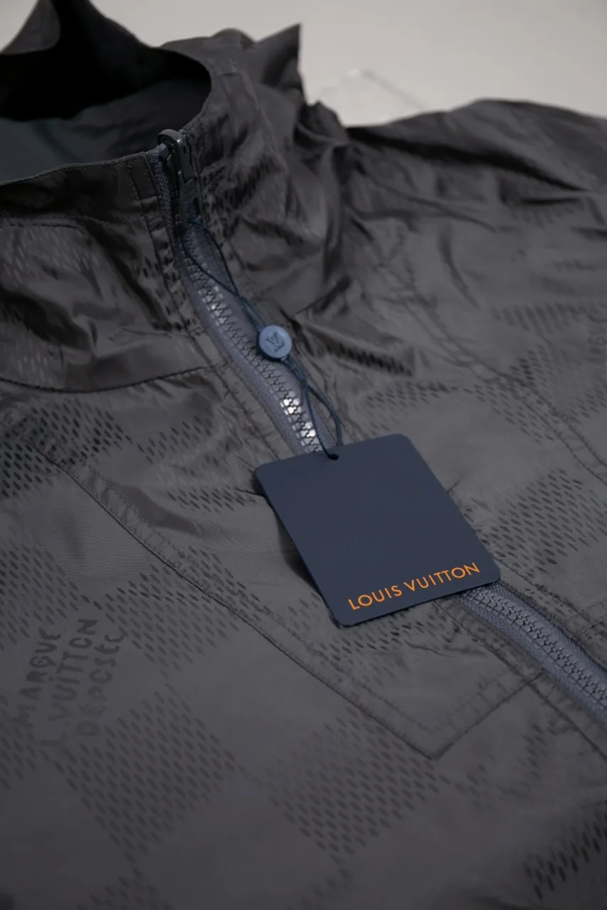 The new LV 24ss double-sided windproof jacket is made of waterproof recycled nylon, making it an energetic choice during the changing seasons. The solid color side is embellished with a Marque L.Vuitton déposée embossed leather patch, which turns over to reveal a full-length Damier jacquard pattern, with the Marque L.Vuitton déposée logo cleverly hidden in it! Unisex size: S.M.L.XL.