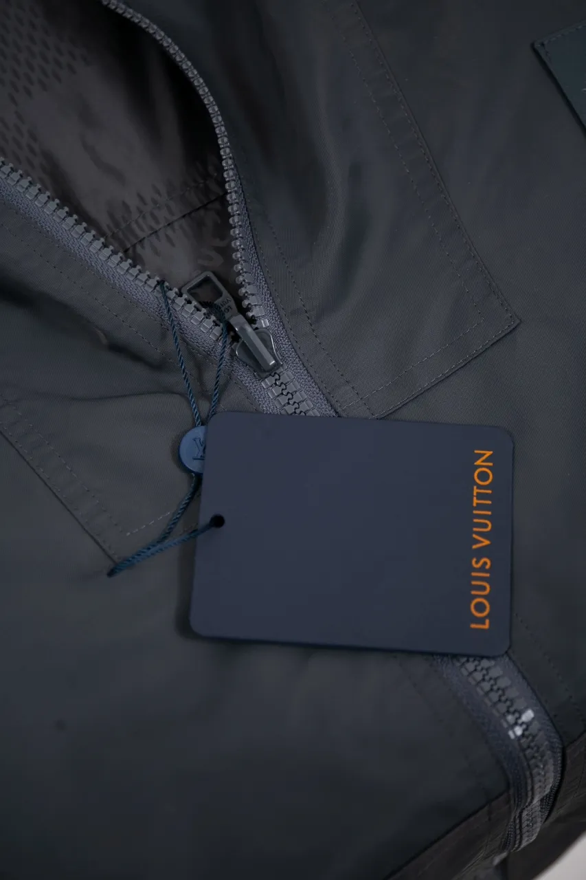 The new LV 24ss double-sided windproof jacket is made of waterproof recycled nylon, making it an energetic choice during the changing seasons. The solid color side is embellished with a Marque L.Vuitton déposée embossed leather patch, which turns over to reveal a full-length Damier jacquard pattern, with the Marque L.Vuitton déposée logo cleverly hidden in it! Unisex size: S.M.L.XL.