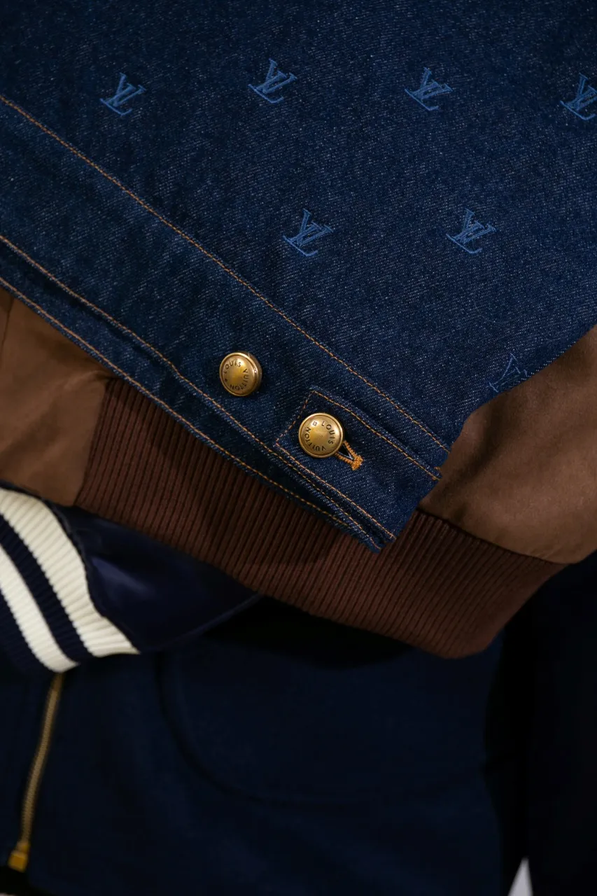 LV Embroidered Denim Tunic Jacket This belted jacket is crafted from washed denim in a classic trucker jacket silhouette, with yarn embroidery depicting the all-over LV Blason pattern and contrasting topstitching and button details. Metallic LV accents and a Damier nubuck label perch on the back make it perfect for the season with the matching trousers.  Regular fit All-over LV Blason embroidery Rear nubuck label with metallic LV accents Denim buttons at front