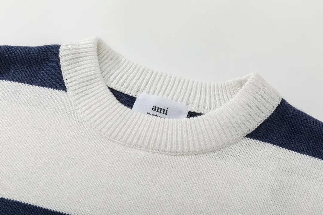 A069# AMI Paris2023 new product. Carefully woven with cotton and wool blended yarn. It has dropped shoulder sleeves and a classic round neck. The blue and white striped body is simple and eye-catching. The red embroidery on the chest easily illustrates the brand identity. Same style for men and women. Color: black and white, orchid white. Size: S-XL
