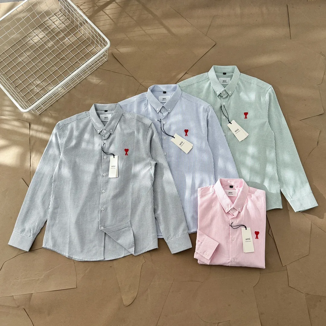 Ami Paris Oxford cotton button-down corner collar casual shirt - small love striped couple's long-sleeved shirt - same style for men and women. Red small love letter embroidery decoration, fashionable and versatile long-sleeved shirt! On sale simultaneously at counters! A well-known French affordable luxury fashion brand. The brand's classic elements are embellishments sought after by major celebrities. Its basic simple design and fashionable style make it a must-have couple's shirt for men and women!  Made of custom-woven 100% Oxford cloth pure cotton, it feels soft and delicate, has excellent moisture absorption and perspiration performance, and is very comfortable and skin-friendly when worn next to the skin! The chest of the shirt is decorated with the classic love letter A logo embroidery. The top-notch embroidery technology is tight, full and full of details, and is cleverly embellished with bright red. It carries all the eye-catching points. It follows the consistent minimalist French attitude. The fabric is soft and comfortable, suitable for any versatile casual shirt couple!  Color: Blue Green Pink Gray Size: S-XXL S: Bust 96 Shoulder 44 Length 68 Sleeve 58 M: Bust 100 Shoulder 46 Length 70 Sleeve 60 L: Bust 104 Shoulder 48 Length 72 Sleeve 62 XL: Bust 108 Shoulder 50 Length 74 Sleeve 63 XXL: Bust 112, shoulder width 52, length 76, sleeve length 64