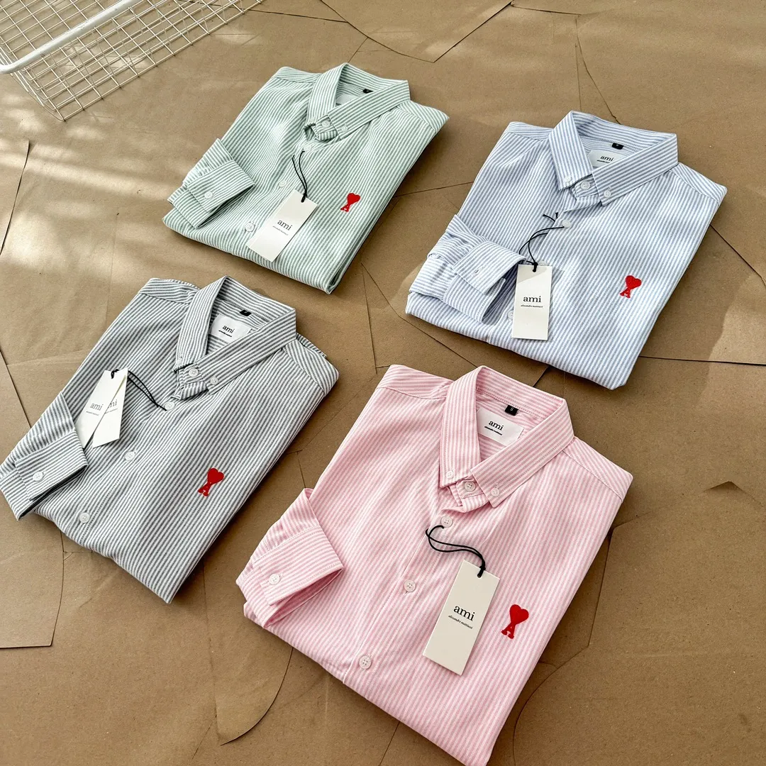 Ami Paris Oxford cotton button-down corner collar casual shirt - small love striped couple's long-sleeved shirt - same style for men and women. Red small love letter embroidery decoration, fashionable and versatile long-sleeved shirt! On sale simultaneously at counters! A well-known French affordable luxury fashion brand. The brand's classic elements are embellishments sought after by major celebrities. Its basic simple design and fashionable style make it a must-have couple's shirt for men and women!  Made of custom-woven 100% Oxford cloth pure cotton, it feels soft and delicate, has excellent moisture absorption and perspiration performance, and is very comfortable and skin-friendly when worn next to the skin! The chest of the shirt is decorated with the classic love letter A logo embroidery. The top-notch embroidery technology is tight, full and full of details, and is cleverly embellished with bright red. It carries all the eye-catching points. It follows the consistent minimalist French attitude. The fabric is soft and comfortable, suitable for any versatile casual shirt couple!  Color: Blue Green Pink Gray Size: S-XXL S: Bust 96 Shoulder 44 Length 68 Sleeve 58 M: Bust 100 Shoulder 46 Length 70 Sleeve 60 L: Bust 104 Shoulder 48 Length 72 Sleeve 62 XL: Bust 108 Shoulder 50 Length 74 Sleeve 63 XXL: Bust 112, shoulder width 52, length 76, sleeve length 64