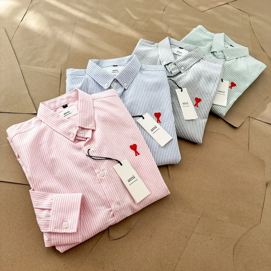 Ami Paris Oxford cotton button-down corner collar casual shirt - small love striped couple's long-sleeved shirt - same style for men and women. Red small love letter embroidery decoration, fashionable and versatile long-sleeved shirt! On sale simultaneously at counters! A well-known French affordable luxury fashion brand. The brand's classic elements are embellishments sought after by major celebrities. Its basic simple design and fashionable style make it a must-have couple's shirt for men and women!  Made of custom-woven 100% Oxford cloth pure cotton, it feels soft and delicate, has excellent moisture absorption and perspiration performance, and is very comfortable and skin-friendly when worn next to the skin! The chest of the shirt is decorated with the classic love letter A logo embroidery. The top-notch embroidery technology is tight, full and full of details, and is cleverly embellished with bright red. It carries all the eye-catching points. It follows the consistent minimalist French attitude. The fabric is soft and comfortable, suitable for any versatile casual shirt couple!  Color: Blue Green Pink Gray Size: S-XXL S: Bust 96 Shoulder 44 Length 68 Sleeve 58 M: Bust 100 Shoulder 46 Length 70 Sleeve 60 L: Bust 104 Shoulder 48 Length 72 Sleeve 62 XL: Bust 108 Shoulder 50 Length 74 Sleeve 63 XXL: Bust 112, shoulder width 52, length 76, sleeve length 64