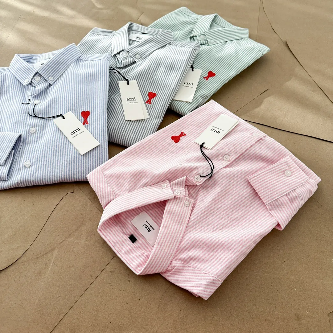 Ami Paris Oxford cotton button-down corner collar casual shirt - small love striped couple's long-sleeved shirt - same style for men and women. Red small love letter embroidery decoration, fashionable and versatile long-sleeved shirt! On sale simultaneously at counters! A well-known French affordable luxury fashion brand. The brand's classic elements are embellishments sought after by major celebrities. Its basic simple design and fashionable style make it a must-have couple's shirt for men and women!  Made of custom-woven 100% Oxford cloth pure cotton, it feels soft and delicate, has excellent moisture absorption and perspiration performance, and is very comfortable and skin-friendly when worn next to the skin! The chest of the shirt is decorated with the classic love letter A logo embroidery. The top-notch embroidery technology is tight, full and full of details, and is cleverly embellished with bright red. It carries all the eye-catching points. It follows the consistent minimalist French attitude. The fabric is soft and comfortable, suitable for any versatile casual shirt couple!  Color: Blue Green Pink Gray Size: S-XXL S: Bust 96 Shoulder 44 Length 68 Sleeve 58 M: Bust 100 Shoulder 46 Length 70 Sleeve 60 L: Bust 104 Shoulder 48 Length 72 Sleeve 62 XL: Bust 108 Shoulder 50 Length 74 Sleeve 63 XXL: Bust 112, shoulder width 52, length 76, sleeve length 64