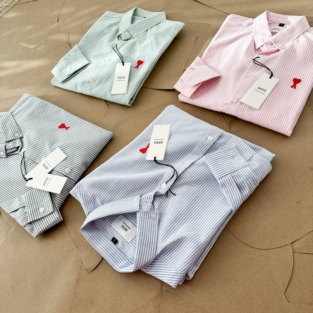Ami Paris Oxford cotton button-down corner collar casual shirt - small love striped couple's long-sleeved shirt - same style for men and women. Red small love letter embroidery decoration, fashionable and versatile long-sleeved shirt! On sale simultaneously at counters! A well-known French affordable luxury fashion brand. The brand's classic elements are embellishments sought after by major celebrities. Its basic simple design and fashionable style make it a must-have couple's shirt for men and women!  Made of custom-woven 100% Oxford cloth pure cotton, it feels soft and delicate, has excellent moisture absorption and perspiration performance, and is very comfortable and skin-friendly when worn next to the skin! The chest of the shirt is decorated with the classic love letter A logo embroidery. The top-notch embroidery technology is tight, full and full of details, and is cleverly embellished with bright red. It carries all the eye-catching points. It follows the consistent minimalist French attitude. The fabric is soft and comfortable, suitable for any versatile casual shirt couple!  Color: Blue Green Pink Gray Size: S-XXL S: Bust 96 Shoulder 44 Length 68 Sleeve 58 M: Bust 100 Shoulder 46 Length 70 Sleeve 60 L: Bust 104 Shoulder 48 Length 72 Sleeve 62 XL: Bust 108 Shoulder 50 Length 74 Sleeve 63 XXL: Bust 112, shoulder width 52, length 76, sleeve length 64