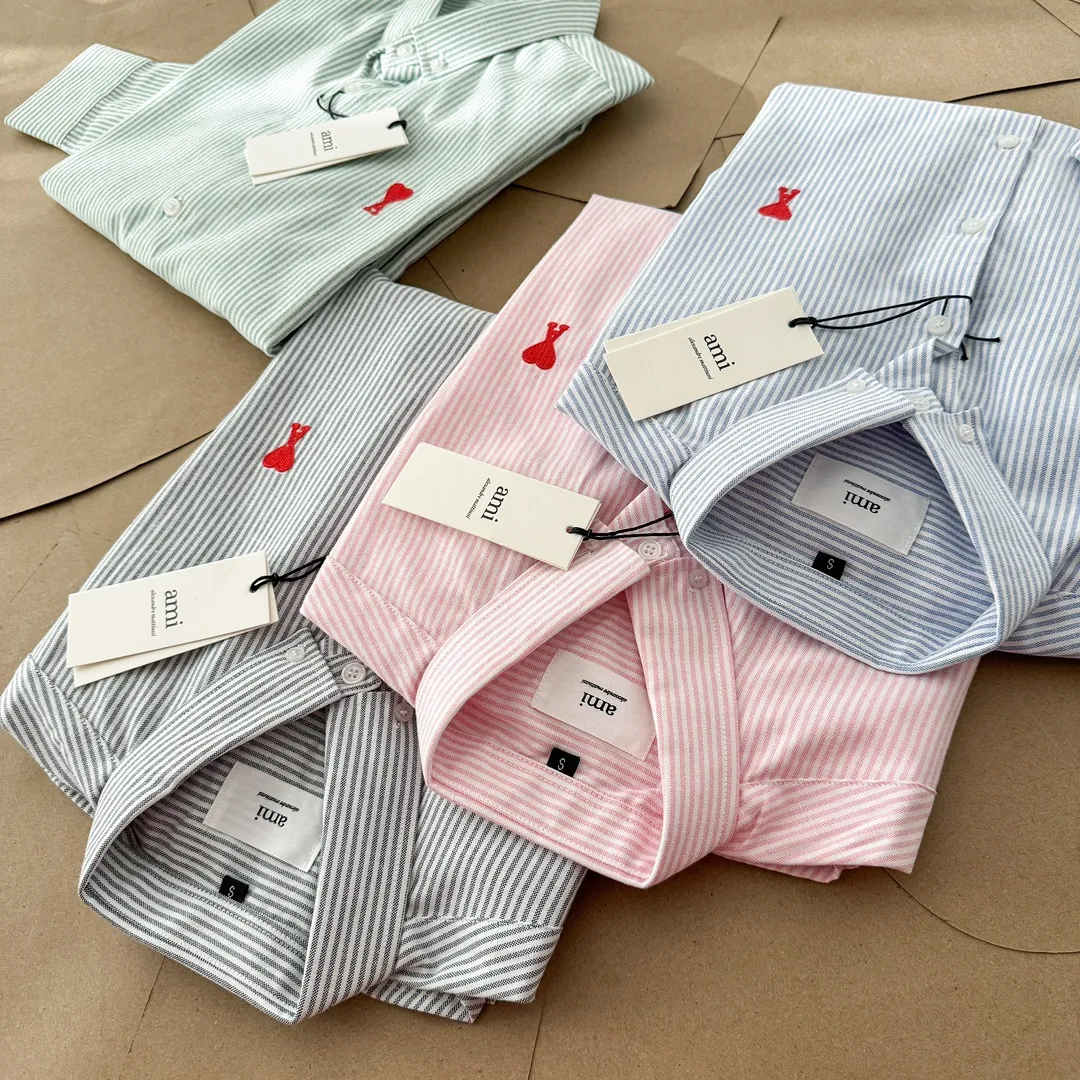 Ami Paris Oxford cotton button-down corner collar casual shirt - small love striped couple's long-sleeved shirt - same style for men and women. Red small love letter embroidery decoration, fashionable and versatile long-sleeved shirt! On sale simultaneously at counters! A well-known French affordable luxury fashion brand. The brand's classic elements are embellishments sought after by major celebrities. Its basic simple design and fashionable style make it a must-have couple's shirt for men and women!  Made of custom-woven 100% Oxford cloth pure cotton, it feels soft and delicate, has excellent moisture absorption and perspiration performance, and is very comfortable and skin-friendly when worn next to the skin! The chest of the shirt is decorated with the classic love letter A logo embroidery. The top-notch embroidery technology is tight, full and full of details, and is cleverly embellished with bright red. It carries all the eye-catching points. It follows the consistent minimalist French attitude. The fabric is soft and comfortable, suitable for any versatile casual shirt couple!  Color: Blue Green Pink Gray Size: S-XXL S: Bust 96 Shoulder 44 Length 68 Sleeve 58 M: Bust 100 Shoulder 46 Length 70 Sleeve 60 L: Bust 104 Shoulder 48 Length 72 Sleeve 62 XL: Bust 108 Shoulder 50 Length 74 Sleeve 63 XXL: Bust 112, shoulder width 52, length 76, sleeve length 64