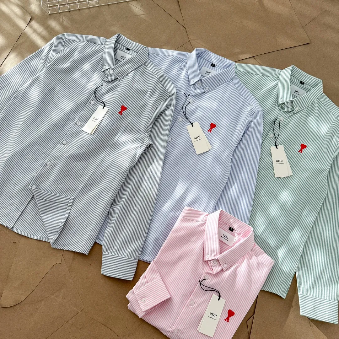 Ami Paris Oxford cotton button-down corner collar casual shirt - small love striped couple's long-sleeved shirt - same style for men and women. Red small love letter embroidery decoration, fashionable and versatile long-sleeved shirt! On sale simultaneously at counters! A well-known French affordable luxury fashion brand. The brand's classic elements are embellishments sought after by major celebrities. Its basic simple design and fashionable style make it a must-have couple's shirt for men and women!  Made of custom-woven 100% Oxford cloth pure cotton, it feels soft and delicate, has excellent moisture absorption and perspiration performance, and is very comfortable and skin-friendly when worn next to the skin! The chest of the shirt is decorated with the classic love letter A logo embroidery. The top-notch embroidery technology is tight, full and full of details, and is cleverly embellished with bright red. It carries all the eye-catching points. It follows the consistent minimalist French attitude. The fabric is soft and comfortable, suitable for any versatile casual shirt couple!  Color: Blue Green Pink Gray Size: S-XXL S: Bust 96 Shoulder 44 Length 68 Sleeve 58 M: Bust 100 Shoulder 46 Length 70 Sleeve 60 L: Bust 104 Shoulder 48 Length 72 Sleeve 62 XL: Bust 108 Shoulder 50 Length 74 Sleeve 63 XXL: Bust 112, shoulder width 52, length 76, sleeve length 64
