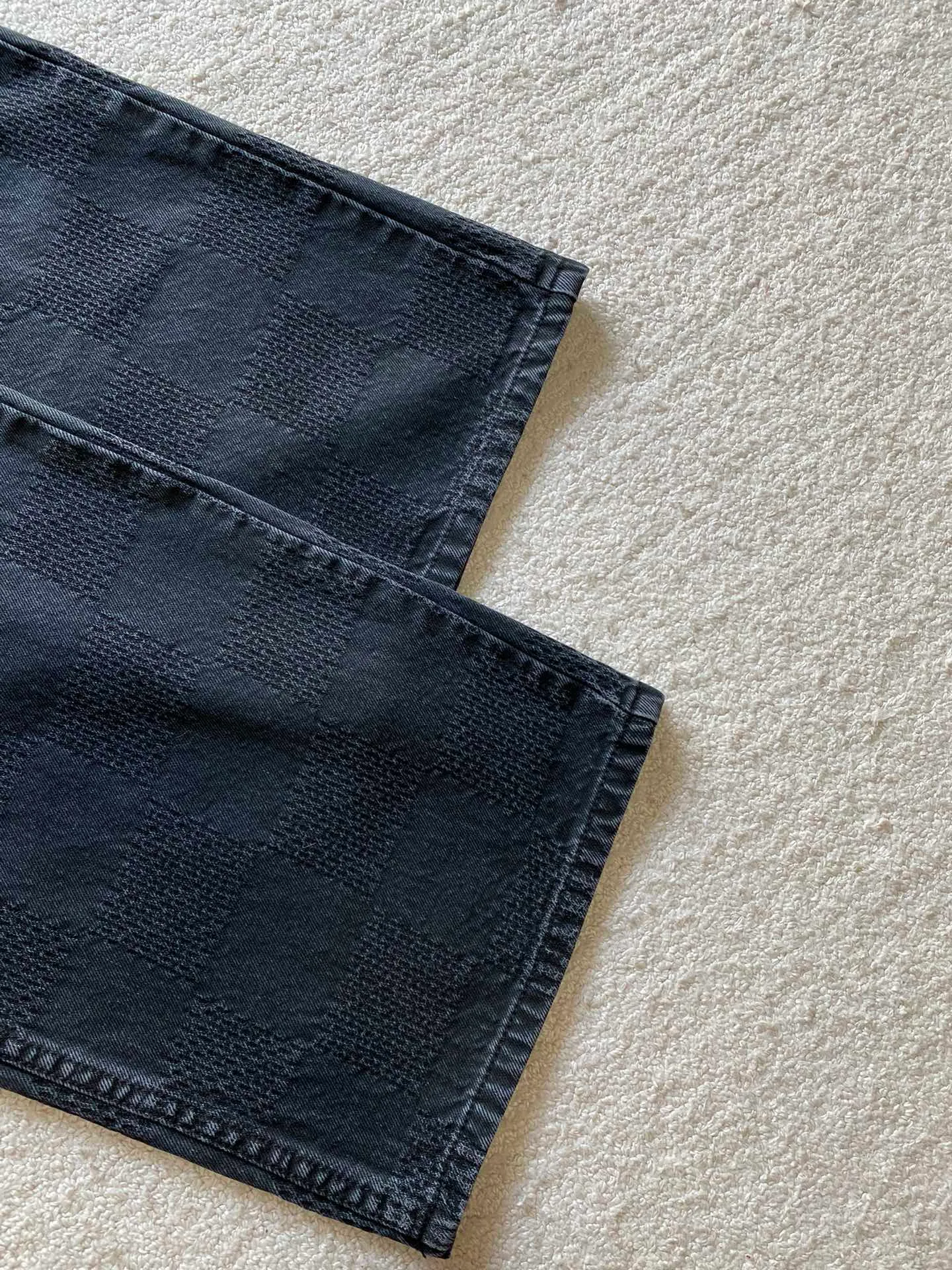 LV black checkerboard denim straight trousers ⚠️Original purchase, 600, skateboard straight version, Marque L. Uuitton deposee logo integrated into 3D Damier jacquard, back Damier label, sand washed distressed, topstitch sewing, placket distressed hardware closure #Logo integrated into 3D Damier jacquard 3D Damier jacquard denim fabric is an innovative fabric that combines jacquard technology and the characteristics of denim cloth. The classic plaid pattern is combined with 3D jacquard technology to weave three-dimensional patterns on the fabric through a loom.  The fabric presents an exquisite plaid pattern in appearance, and the pattern is made three-dimensional and layered through jacquard technology. At the same time, it retains the original tough, wear-resistant and durable properties of denim, making the clothes more durable.  # Sandwashed, Faded and Distressed Effect Sandwashed, faded and distressed denim fabric is a specially treated denim fabric that exhibits a whitened and distressed effect. This fabric uses a sand-washing process and special dyeing technology to create a natural wear and fading effect on the denim after washing, making it look more vintage and historical.  #skateboard straight jeans version Skateboard jeans are usually designed to be looser to accommodate the large movements and squatting postures during skateboarding. Jeans have a straight shape and a consistent width from hip to hem. Suitable for all body types, these straight-leg skateboard pants are designed with comfort and freedom in mind for skateboarding.