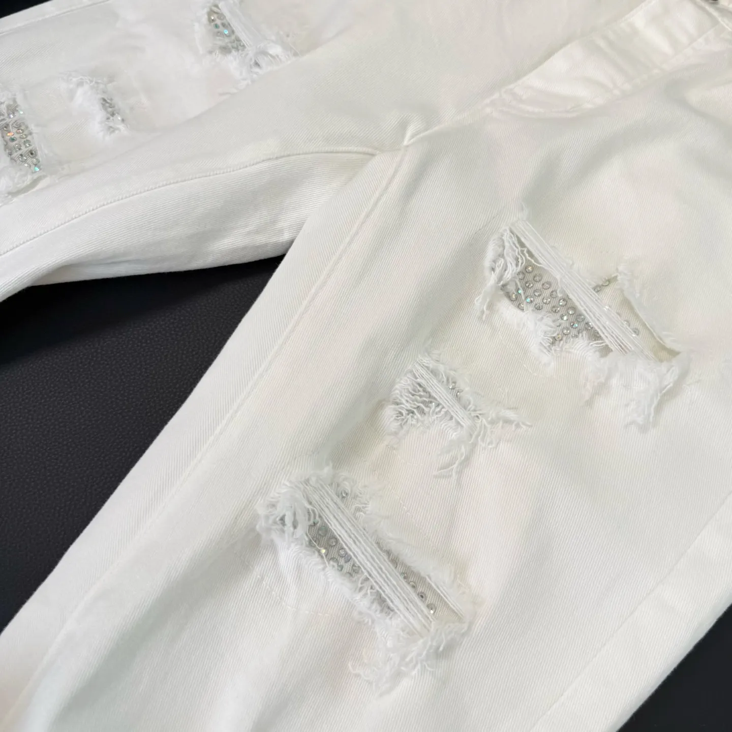 P260 💰Top model number: D289 Non-market Amiri white hot diamond patched ripped high street slim jeans • amiri is transliterated as Emil, which is the name of the founder. Mike Amiri, the founder of amiri, grew up in Los Angeles, USA. He was influenced by local street culture and Punk Rock since childhood, so he founded the amiri brand named after himself. A variety of trendy brand clothing meets the needs of different fashion players. Amiri clothing has novel and unique styles and is a well-known street brand in the United States. The styles and styles of many clothes are loved by many street photographers. The various clothing styles meet the dressing needs of different people, show their unique temperament, and show the trend of dressing. amiri's jeans are relatively famous. Not only do they have many styles, but the quality of the jeans is also very good. Many celebrities have also worn amiri brand jeans.  The jeans of the amiri brand break through the production process and cutting of the original jeans. The fabrics are relatively soft and comfortable, and are not as hard as some jeans, which can irritate the skin and cause the skin to bleed when worn. Los Angeles trendy brand Amiri's jeans are made with great detail from tailoring to texture, adding wrinkles, bullet holes, damage and other details to add to the trendiness of the jeans. You can choose the style that suits you according to your own needs. Only when you wear a suitable style can you have a certain sense of fashion.  In recent years, high street has become a word that appears more and more frequently in men's clothing. High street style has also become an important direction for everyone's matching. High street-related items basically cannot avoid oversize or drop-shoulder tops. The lower body is matched with trackpants or tight-fitting denim. In my opinion, the most representative one may be denim. What I bring to you today is the MX1 hot-drilled patch denim worn by many Internet celebrities. It is made by a large washing factory in Guangzhou. The front and back have frayed trouser legs and holes. Full of high-end sense. Knee part damage design with leather patchwork design. Already used as facade design. Leather waist nameplate. Customized crotch placket hardware. Engraving mold opening. The focus of this style is not on washing, but on the shape and version of the damage. The secret lies in the craftsmanship of the master. Later, the cost of fraying, horse cutting, knife cutting, etc. These hand-made products are far beyond comparison with assembly line products.  Color: Picture color Size: 30-31-32-33-34-36