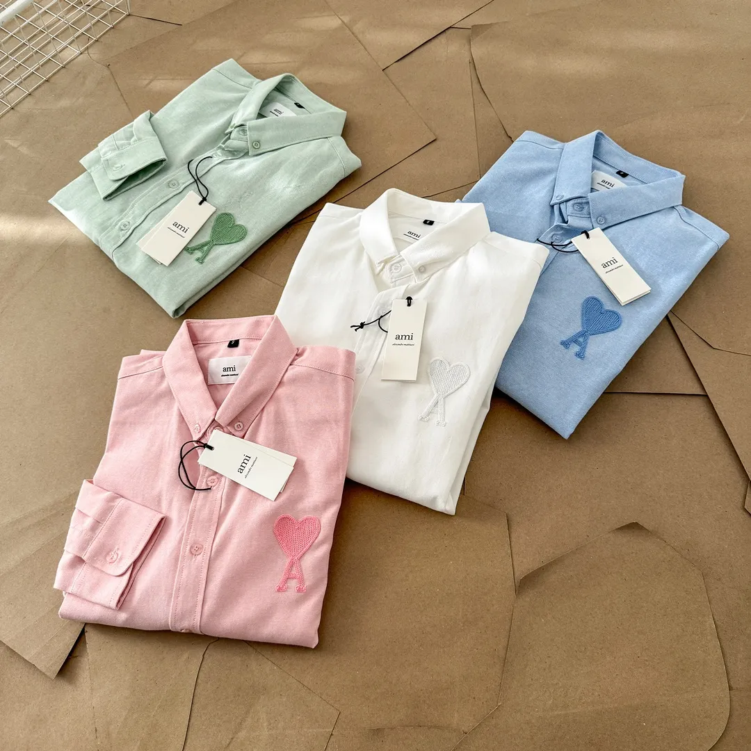 Ami Paris same color large heart embroidered Oxford cloth cotton button corner collar casual shirt - same style for men and women. Fashionable and versatile long-sleeved shirt with same color letter embroidery decoration! On sale simultaneously at counters!  Made of custom-woven 100% Oxford cloth pure cotton, it feels soft and delicate, has excellent moisture absorption and perspiration performance, and is very comfortable and skin-friendly when worn next to the skin! The chest of the shirt is decorated with the classic love letter A logo embroidery. The top-notch embroidery technology is tight, full and full of details, and is cleverly embellished with bright red. It carries all the eye-catching points. It follows the consistent minimalist French attitude. The fabric is soft and comfortable, suitable for any versatile casual shirt couple!  Color: Green Pink White Blue Size: S-M-L-XL Shoulder Width: 47-48-49-50 Bust: 106-110-114-118 Length: 71-73-75-76 Sleeve Length: 60-61-62-63