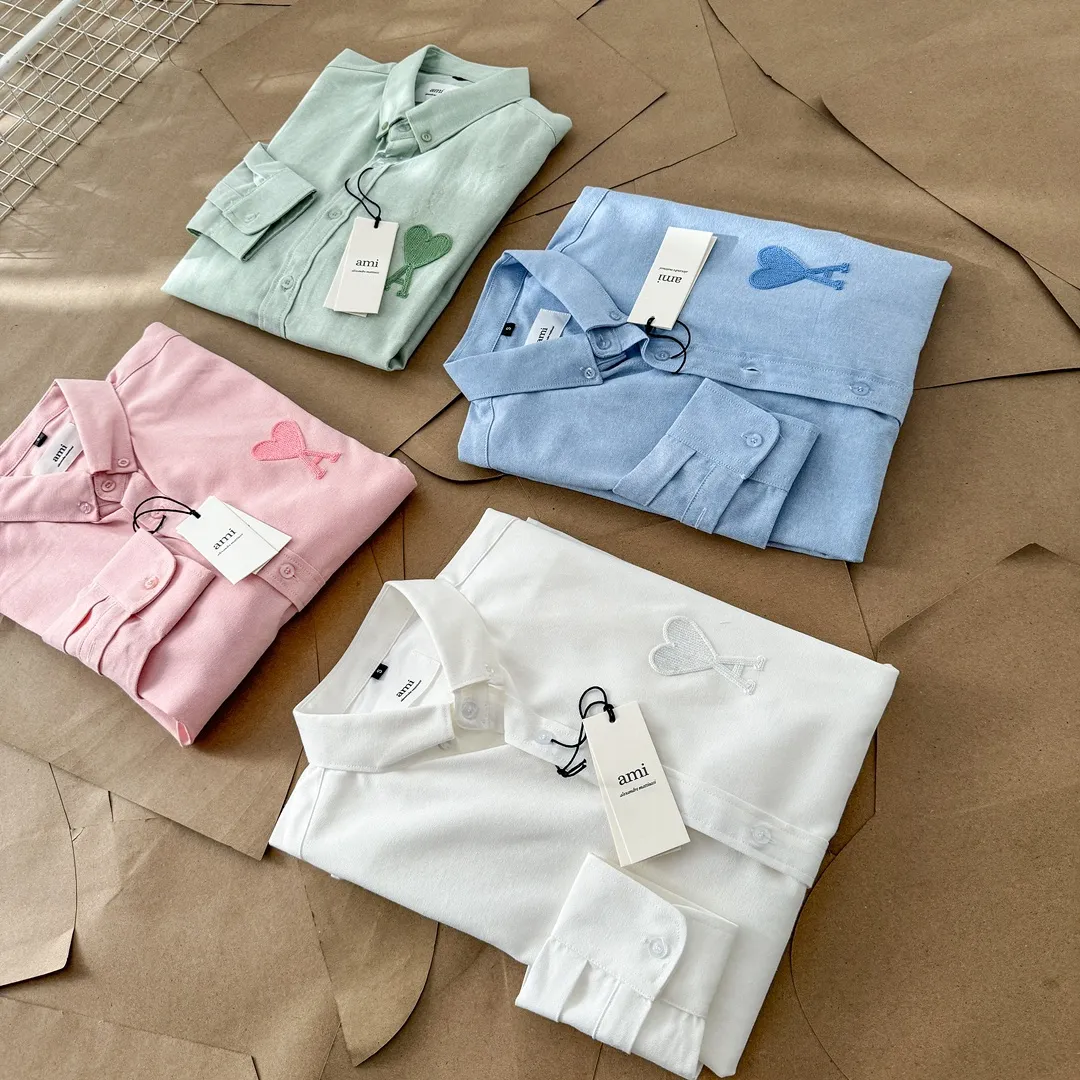 Ami Paris same color large heart embroidered Oxford cloth cotton button corner collar casual shirt - same style for men and women. Fashionable and versatile long-sleeved shirt with same color letter embroidery decoration! On sale simultaneously at counters!  Made of custom-woven 100% Oxford cloth pure cotton, it feels soft and delicate, has excellent moisture absorption and perspiration performance, and is very comfortable and skin-friendly when worn next to the skin! The chest of the shirt is decorated with the classic love letter A logo embroidery. The top-notch embroidery technology is tight, full and full of details, and is cleverly embellished with bright red. It carries all the eye-catching points. It follows the consistent minimalist French attitude. The fabric is soft and comfortable, suitable for any versatile casual shirt couple!  Color: Green Pink White Blue Size: S-M-L-XL Shoulder Width: 47-48-49-50 Bust: 106-110-114-118 Length: 71-73-75-76 Sleeve Length: 60-61-62-63
