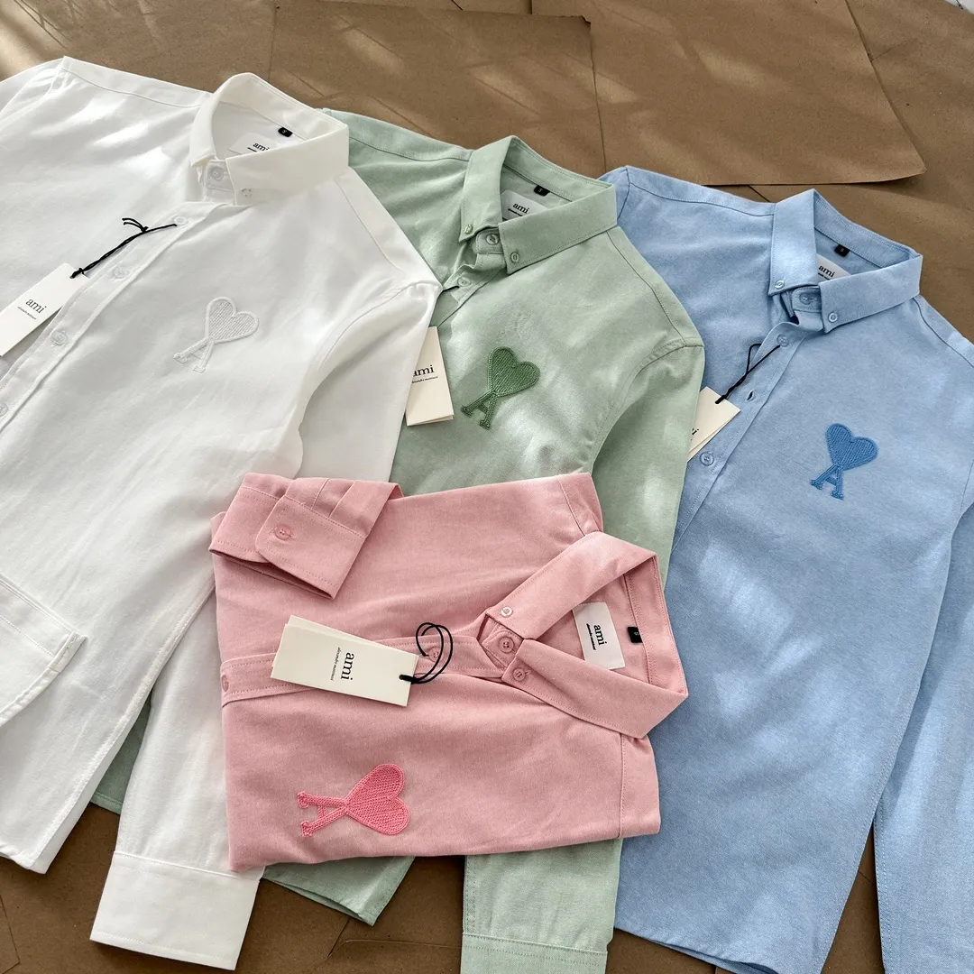 Ami Paris same color large heart embroidered Oxford cloth cotton button corner collar casual shirt - same style for men and women. Fashionable and versatile long-sleeved shirt with same color letter embroidery decoration! On sale simultaneously at counters!  Made of custom-woven 100% Oxford cloth pure cotton, it feels soft and delicate, has excellent moisture absorption and perspiration performance, and is very comfortable and skin-friendly when worn next to the skin! The chest of the shirt is decorated with the classic love letter A logo embroidery. The top-notch embroidery technology is tight, full and full of details, and is cleverly embellished with bright red. It carries all the eye-catching points. It follows the consistent minimalist French attitude. The fabric is soft and comfortable, suitable for any versatile casual shirt couple!  Color: Green Pink White Blue Size: S-M-L-XL Shoulder Width: 47-48-49-50 Bust: 106-110-114-118 Length: 71-73-75-76 Sleeve Length: 60-61-62-63