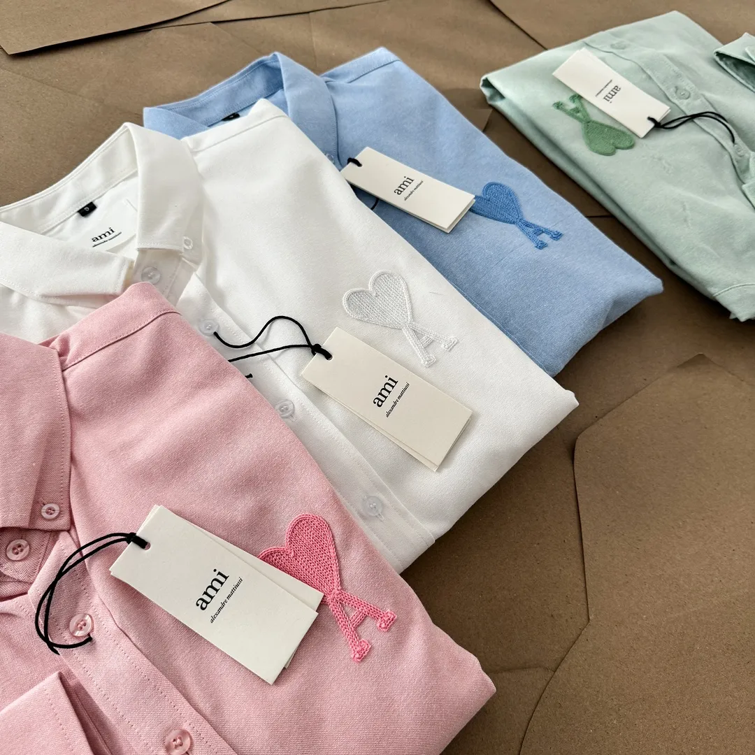 Ami Paris same color large heart embroidered Oxford cloth cotton button corner collar casual shirt - same style for men and women. Fashionable and versatile long-sleeved shirt with same color letter embroidery decoration! On sale simultaneously at counters!  Made of custom-woven 100% Oxford cloth pure cotton, it feels soft and delicate, has excellent moisture absorption and perspiration performance, and is very comfortable and skin-friendly when worn next to the skin! The chest of the shirt is decorated with the classic love letter A logo embroidery. The top-notch embroidery technology is tight, full and full of details, and is cleverly embellished with bright red. It carries all the eye-catching points. It follows the consistent minimalist French attitude. The fabric is soft and comfortable, suitable for any versatile casual shirt couple!  Color: Green Pink White Blue Size: S-M-L-XL Shoulder Width: 47-48-49-50 Bust: 106-110-114-118 Length: 71-73-75-76 Sleeve Length: 60-61-62-63
