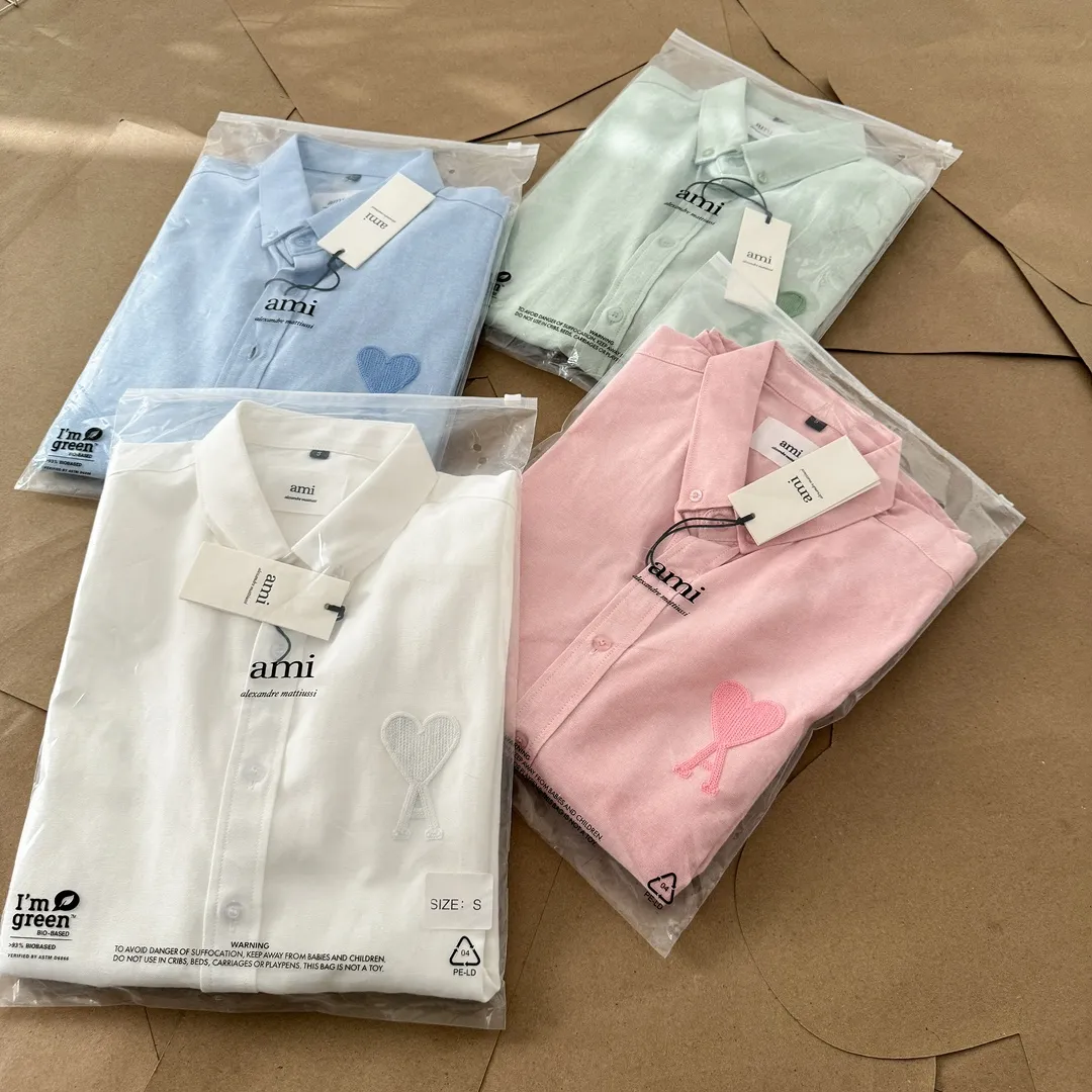 Ami Paris same color large heart embroidered Oxford cloth cotton button corner collar casual shirt - same style for men and women. Fashionable and versatile long-sleeved shirt with same color letter embroidery decoration! On sale simultaneously at counters!  Made of custom-woven 100% Oxford cloth pure cotton, it feels soft and delicate, has excellent moisture absorption and perspiration performance, and is very comfortable and skin-friendly when worn next to the skin! The chest of the shirt is decorated with the classic love letter A logo embroidery. The top-notch embroidery technology is tight, full and full of details, and is cleverly embellished with bright red. It carries all the eye-catching points. It follows the consistent minimalist French attitude. The fabric is soft and comfortable, suitable for any versatile casual shirt couple!  Color: Green Pink White Blue Size: S-M-L-XL Shoulder Width: 47-48-49-50 Bust: 106-110-114-118 Length: 71-73-75-76 Sleeve Length: 60-61-62-63