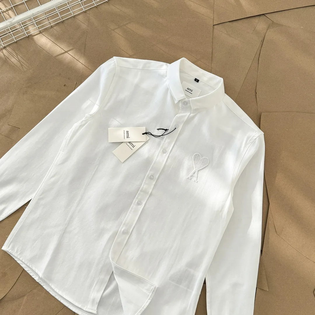 Ami Paris same color large heart embroidered Oxford cloth cotton button corner collar casual shirt - same style for men and women. Fashionable and versatile long-sleeved shirt with same color letter embroidery decoration! On sale simultaneously at counters!  Made of custom-woven 100% Oxford cloth pure cotton, it feels soft and delicate, has excellent moisture absorption and perspiration performance, and is very comfortable and skin-friendly when worn next to the skin! The chest of the shirt is decorated with the classic love letter A logo embroidery. The top-notch embroidery technology is tight, full and full of details, and is cleverly embellished with bright red. It carries all the eye-catching points. It follows the consistent minimalist French attitude. The fabric is soft and comfortable, suitable for any versatile casual shirt couple!  Color: Green Pink White Blue Size: S-M-L-XL Shoulder Width: 47-48-49-50 Bust: 106-110-114-118 Length: 71-73-75-76 Sleeve Length: 60-61-62-63