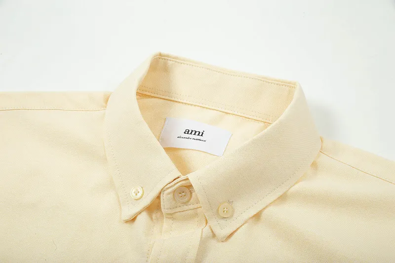 AMI Paris classic autumn heart embroidery in the same color on the chest. Casual cotton solid color short-sleeved Oxford shirt. Original custom-made 180g pure cotton fabric. Loose off-shoulder version. Same style for men and women. Color: Tianlan, white, green, pink, yellow, size: S-XL