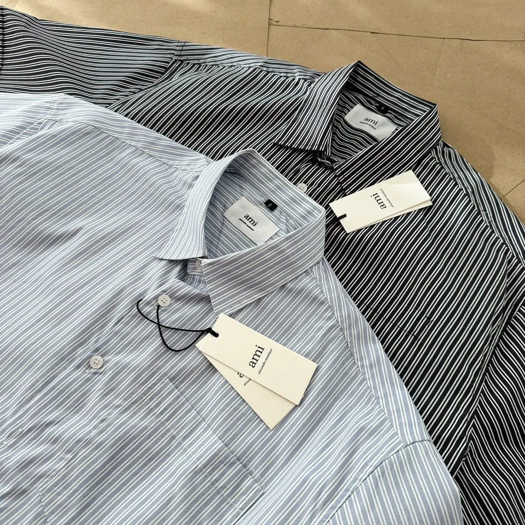 Ami Paris men's 24 spring and summer new love style loose cotton striped short shirt with the same color love at the back of the neck - the same style for men and women. The same color small love embroidery decoration at the back of the neck is fashionable and versatile long-sleeved shirt! On sale simultaneously at counters!  A well-known French affordable luxury fashion brand. The brand's classic elements are embellishments sought after by major celebrities. Its basic simple design and fashionable style make it a must-have couple's shirt for men and women!  Made of custom-woven 100% silk cotton material, it feels soft and delicate, has excellent moisture absorption and perspiration performance, and is very comfortable and skin-friendly when worn next to the skin! The simple and versatile pockets on the chest follow the consistent minimalist French attitude. The fabric is soft and comfortable, suitable for any versatile casual shirt couple!  Color: Blue Black Size: S-XL S: Bust 102, Shoulder 47, Length 70 M: Bust 106, Shoulder 48, Length 72 L: Bust 110, Shoulder 49, Length 74 XL: Bust 114, Shoulder 50, Length 76