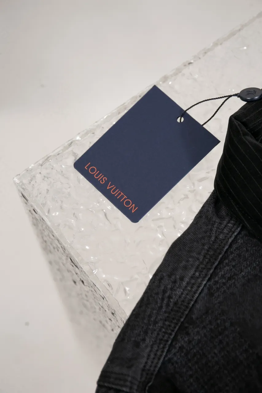 LV DAMIER Cotton Work Belt Jacket This washed denim belt jacket continues the American workwear style of the 2024 autumn and winter show, incorporating the Marque L.Vuitton déposée logo into Damier jacquard canvas. One of the LV Saddle leather patch pockets and nubuck collar with embossed Epi graphic. Buttons add a dandy touch to the cuffs and waist straps, and the unlined design is perfect for different seasons.  Regular fit Marque L.Vuitton déposée logo in Damier jacquard LV Saddle patch on lower left pocket Nubuck collar with Epi embossing Zip front with LV stamped zipper pull Patch pockets Studs Adjustable straps with buttons at cuffs and waist