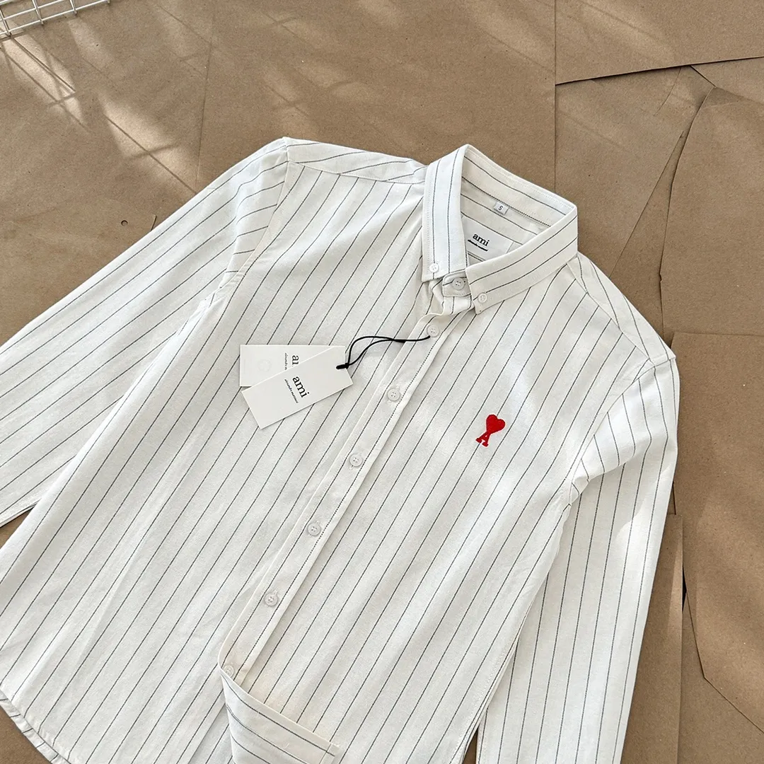 Ami Paris Oxford cloth cotton button-down corner collar casual shirt-little red heart striped couple's long-sleeved shirt-same style for men and women. Red little love letter embroidery decoration fashionable and versatile long-sleeved shirt! On sale simultaneously at counters!  A well-known French affordable luxury fashion brand. The brand's classic elements are embellishments sought after by major celebrities. Its basic simple design and fashionable style make it a must-have couple's shirt for men and women!  Made of custom-woven 100% Oxford cloth pure cotton, it feels soft and delicate, has excellent moisture absorption and perspiration performance, and is very comfortable and skin-friendly when worn next to the skin! The chest of the shirt is decorated with the classic love letter A logo embroidery. The top-notch embroidery technology is tight, full and full of details, and is cleverly embellished with bright red. It carries all the eye-catching points. It follows the consistent minimalist French attitude. The fabric is soft and comfortable, suitable for any versatile casual shirt couple!  Color: off-white Size: S-XXL S: Bust 96 Shoulder width 44 Length 68 Sleeve length 58 M: Bust 100 Shoulder width 46 Length 70 Sleeve length 60 L: Bust 104 Shoulder width 48 Length 72 Sleeve length 62 XL: Bust 108 Shoulder width 50 Length 74 Sleeve length 63 XXL: Bust 112 Shoulder width 52, clothing length 76, sleeve length 64