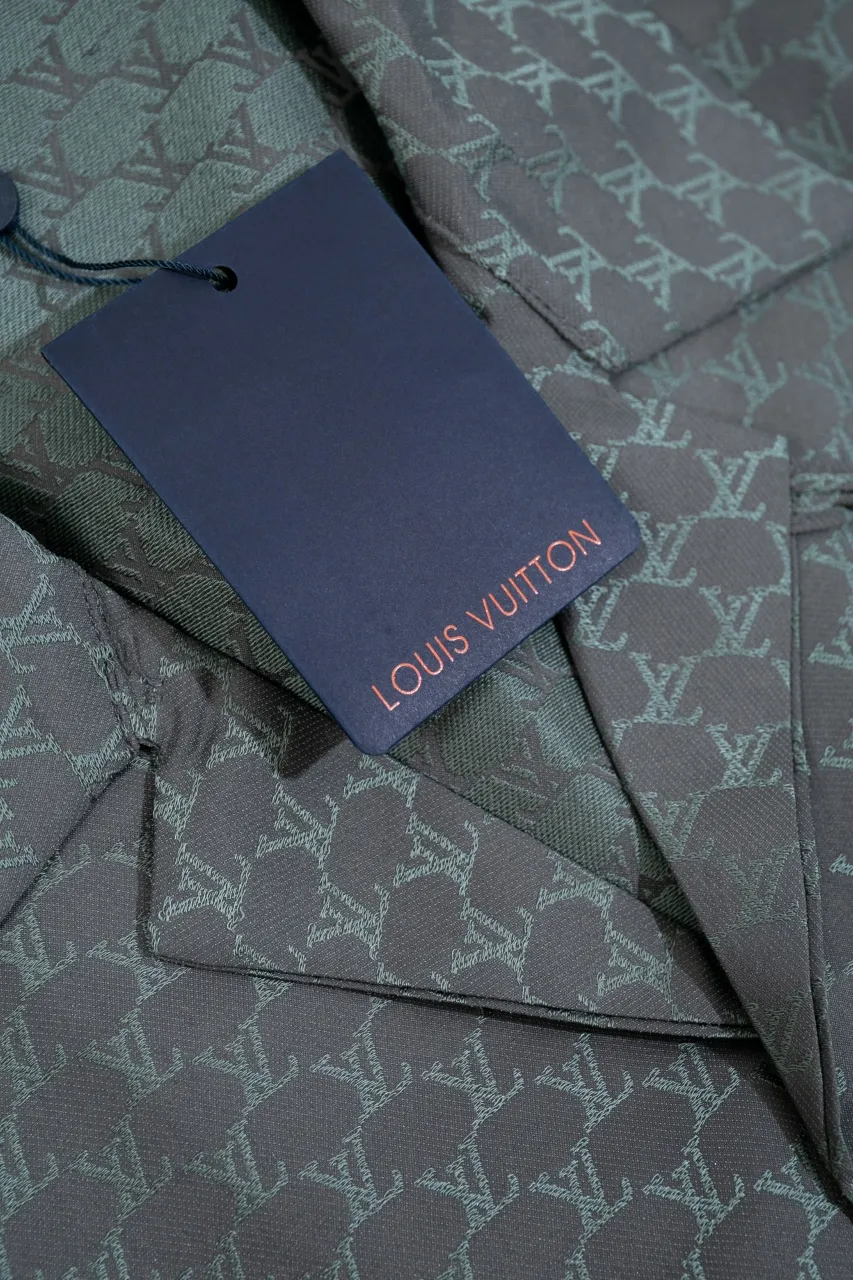 The LV 24SS short-sleeved shirt interprets the brand's classic elements with a modern style and makes an eye-catching appearance in the 2024 spring and summer show. Bright tones depict an enlarged version of the Damier pattern, the Marque L. Vuitton Déposée logo is subtly integrated into the plaid, and the military stand collar adds a fresh touch. Same style for men and women.