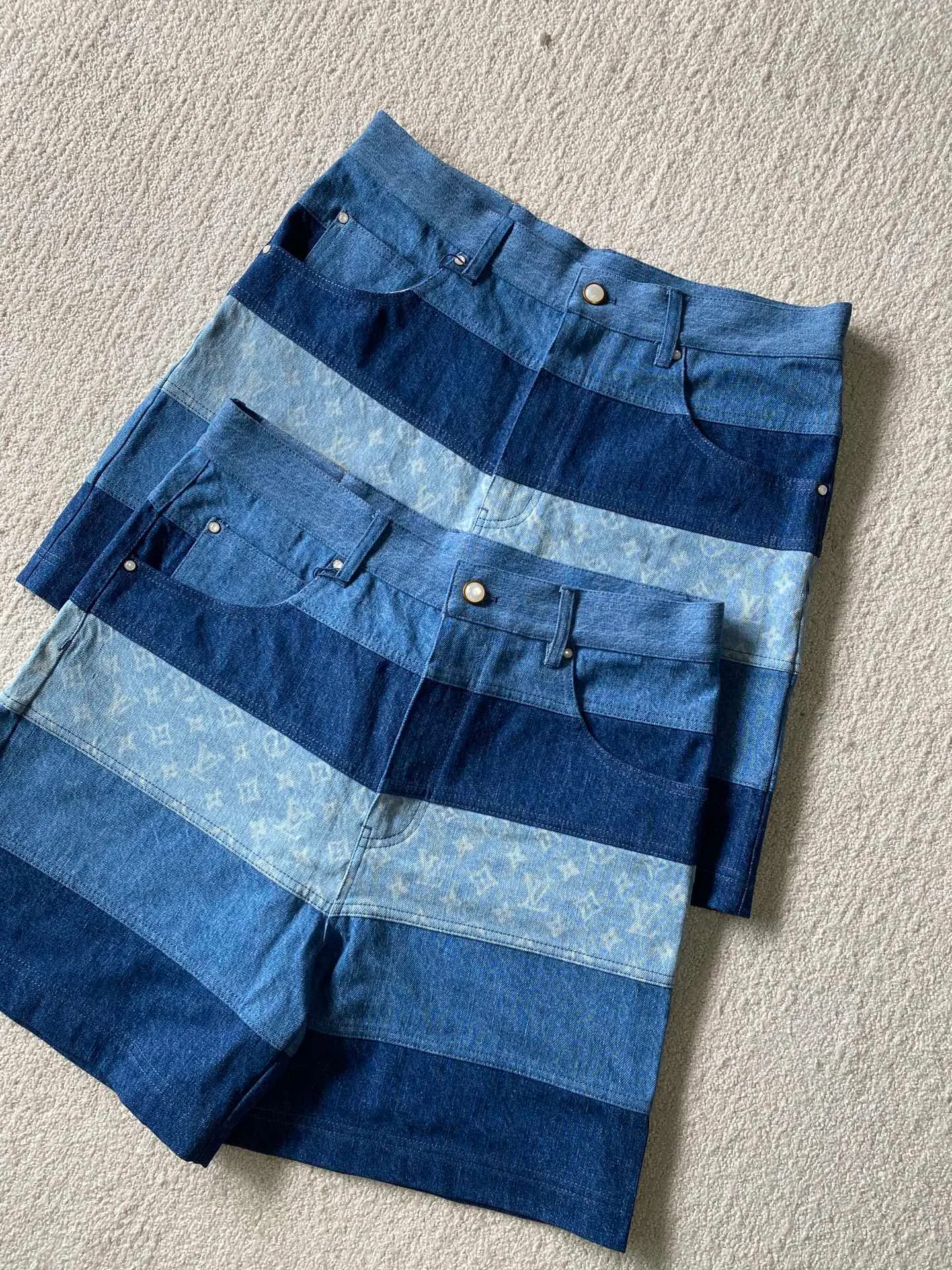 LV denim patchwork shorts ⚠️Original purchase: 500; soft denim fabric, casual fit, patchwork ribbons with Monogram print, Damier nubuck label on the back, MarqueL.Uuitton deposee logo, pearlescent buttons, pearlescent studs, full set of accessories #customized denim shirt fabric The warp yarns of customized denim fabrics are dyed indigo and the weft yarns are kept white. This results in the denim fabric being indigo blue on the front and white on the back. This fabric with a denim structure is created based on the original board production process. In addition to its thick texture, it also has good breathability.  #Patchwork Ribbon Layout Monogram Print The design style of presbyopia elements in the patchwork position is made using laser printing technology. The laser printing process is an advanced printing technology that uses high-energy laser beams to directly evaporate dyes into a gaseous state and spray the dyes onto the fabric through airflow to form the desired pattern. Achieve fine pattern output and ensure the clarity and fineness of printed patterns. After printing, the fabric is dried and fixed to ensure that the dye is firm and does not fade.  #patchwork stripes patchwork patchwork clothing technology connects fabrics of different colors together through specific sewing methods to create unique visual effects and increase the complexity, artistry and layering of clothing. Pattern sewing technology restores the pattern splicing process, restores stitch length, stitch density and other parameters, as well as the correct sewing methods and steps.  # Suede leather printing with hardware accessories. The leather grid on the waist is matched with LV hardware. The original leather brand has an iron mold pattern in the same color. It is made of genuine first-layer cowhide suede. The quality is different from synthetic leather. The placket zipper opening and closing design, a full set of molded custom-made pearlescent button accessories, and clear and delicate engravings; the basic accessories are fully equipped.