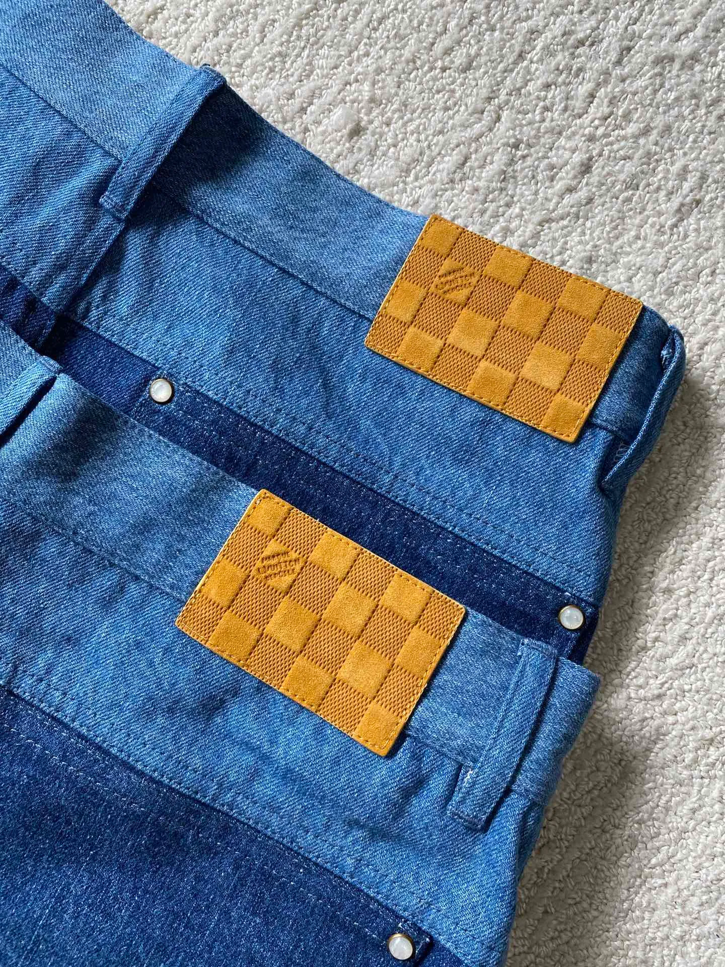 LV denim patchwork shorts ⚠️Original purchase: 500; soft denim fabric, casual fit, patchwork ribbons with Monogram print, Damier nubuck label on the back, MarqueL.Uuitton deposee logo, pearlescent buttons, pearlescent studs, full set of accessories #customized denim shirt fabric The warp yarns of customized denim fabrics are dyed indigo and the weft yarns are kept white. This results in the denim fabric being indigo blue on the front and white on the back. This fabric with a denim structure is created based on the original board production process. In addition to its thick texture, it also has good breathability.  #Patchwork Ribbon Layout Monogram Print The design style of presbyopia elements in the patchwork position is made using laser printing technology. The laser printing process is an advanced printing technology that uses high-energy laser beams to directly evaporate dyes into a gaseous state and spray the dyes onto the fabric through airflow to form the desired pattern. Achieve fine pattern output and ensure the clarity and fineness of printed patterns. After printing, the fabric is dried and fixed to ensure that the dye is firm and does not fade.  #patchwork stripes patchwork patchwork clothing technology connects fabrics of different colors together through specific sewing methods to create unique visual effects and increase the complexity, artistry and layering of clothing. Pattern sewing technology restores the pattern splicing process, restores stitch length, stitch density and other parameters, as well as the correct sewing methods and steps.  # Suede leather printing with hardware accessories. The leather grid on the waist is matched with LV hardware. The original leather brand has an iron mold pattern in the same color. It is made of genuine first-layer cowhide suede. The quality is different from synthetic leather. The placket zipper opening and closing design, a full set of molded custom-made pearlescent button accessories, and clear and delicate engravings; the basic accessories are fully equipped.