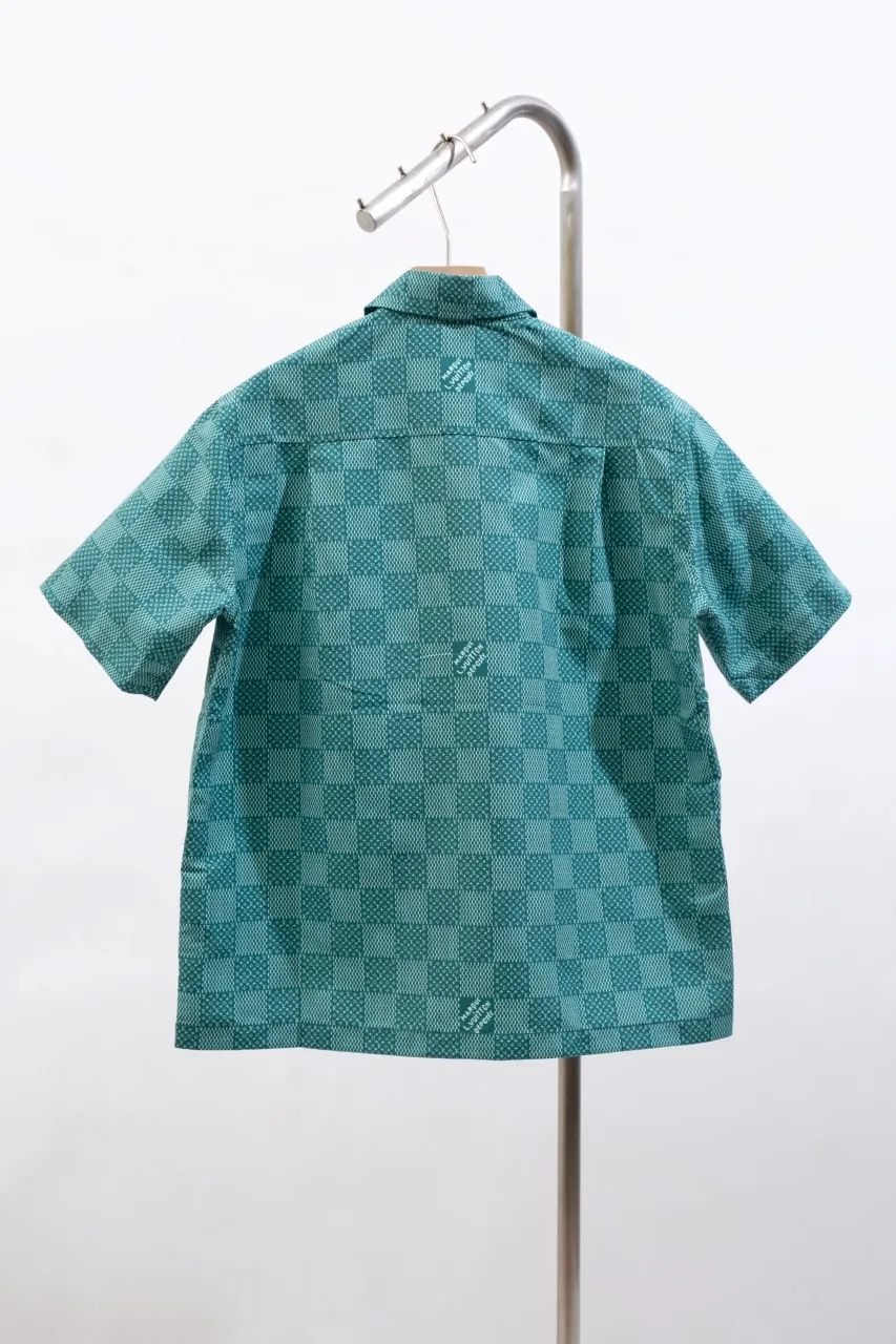 The new LV 24ss short-sleeved shirt is made of lightweight cotton with a full-length Damier Monogram pattern, integrating pocket Monogram elements and the chic Marque L.Vuitton Déposée logo into a checkered pattern. It adds eye-catching style to casual looks and pairs well with the matching beach shorts. Same style for men and women Size: S.M.L.XL