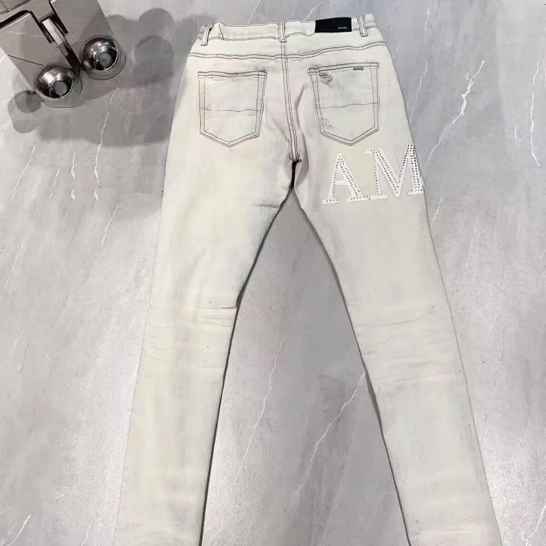 P156 model number Cc818 AMIRI white ripped high street jeans with diamonds! The transliteration of amiri is Emil, which is the name of the founder. Mike Amiri, the founder of amiri, grew up in Los Angeles, USA. He was influenced by local street culture and Punk Rock since he was a child, so he founded the amiri brand named after himself. A variety of trendy clothing meets the needs of different fashion players. Amiri clothing has novel and unique styles and is a well-known street brand in the United States. The styles and styles of many clothes are loved by many street photographers. The various clothing styles meet the dressing needs of different people, show their unique temperament, and show the trend of dressing. amiri's jeans are relatively famous. Not only do they have many styles, but the quality of their denim jackets is also very good. Many celebrities have also worn the amiri brand's denim series. The fabric is made of 100% cotton denim! High temperature setting, heavy sand washing, never fade, full of fashion! All made to order! -The colorful embroidery on the chest is so tense and the embroidery is neat! Imported machine for work! quality assurance!  -The entire garment is made with fine workmanship. Each seam is pressed using a double-needle machine. This stitching is a test of the workers' skills. If it goes astray, the entire garment will be scrapped. The hardware is custom-made, with exclusive logos, and is a one-to-one replica of the original! Original trademark! The fit is loose and slimming! Color: Picture color Size: m-2xl