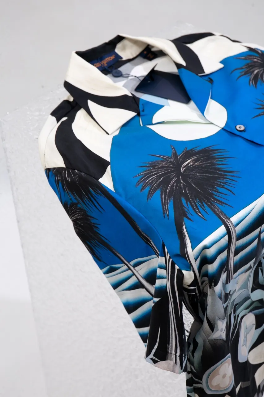 The new LV 24ss spring and summer shirt depicts a moonlit beach night on a tropical island with an all-over Damier Pacific pattern, with Monogram flowers hidden among lush plants, and a Damier checkerboard pattern on the hem. Made from comfortable cotton in a classic silhouette, it's perfect for a cozy vacation. Same style for men and women Size: S.M.L.XL