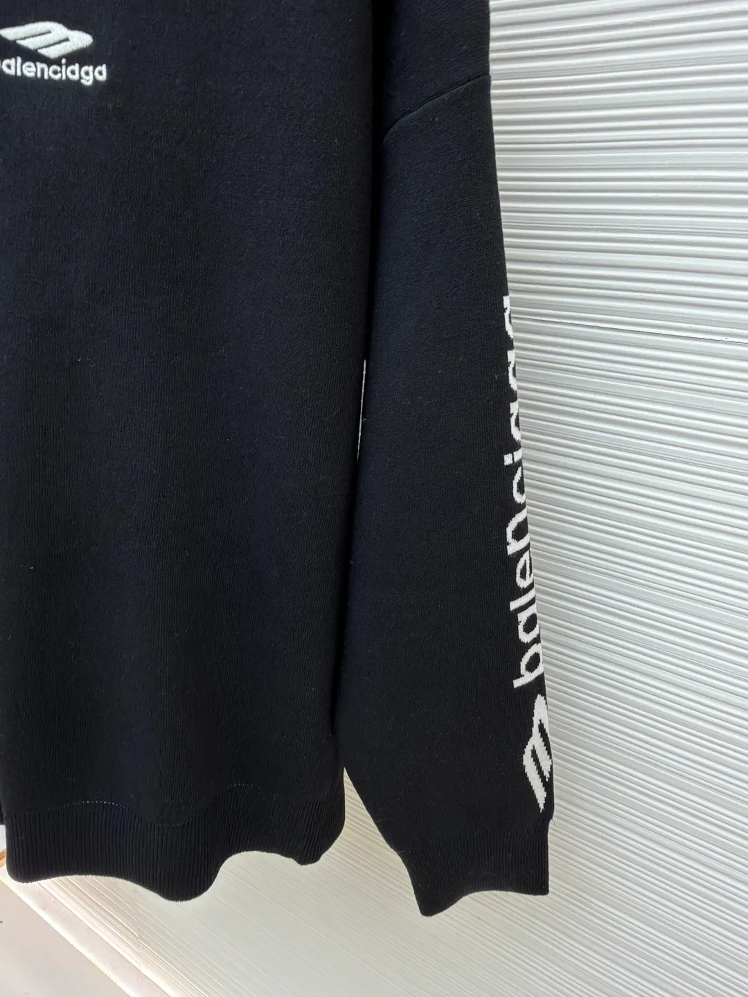 Balenciaga SKI ski series wool knitted sweater ●Original version: purchased and developed by 13306 ●Item number: 1681715-A75 ●Fabric: wool blended fabric ●Technology: knitted production ●Color: black ●Version: Loose version ●Weight: about 860 grams ●Size: XS-S-M ●Description: The main body of the fabric is made of high-quality wool blend. The addition of wool not only provides the iconic soft touch and luxurious luster, but also gives the clothing natural temperature regulation and moisture wicking properties. This means it can effectively lock in body temperature in cold environments, while helping water evaporate to keep skin dry when exercise generates heat. Pure wool may be warm but can be heavy and prone to shrinkage. The blending technology used by Balenciaga must incorporate other natural fibers to optimize the durability, wrinkle resistance and morphological stability of the fabric. The determination of this blending ratio is an exquisite balance between the brand's pursuit of ultimate comfort and meeting the actual needs of skiing. Lycra double-sided bottom technology is used on the hem and the inside of the cuffs of the clothing. This refers to the highly elastic Lycra fiber being woven into a double-layer structure to form a closing edge with strong resilience. Complexity reflected: The core of this craft lies in the "double side". It is not a simple rib, but uses complex double-sided knitting technology to give a smooth and delicate visual effect to both the inside and outside, while forming an "invisible" strong bundle on the inside. The purpose is: Pressure-free comfort: The elasticity provided by Lycra is dynamic, fast enough, and does not restrict body movements, achieving the unity of sports function and comfort. The overall wiring is straight and delicate, the fabric is comfortable and soft, and the color is consistent without color difference. It can be matched with the same style to create a fashionable look and control various occasions. Customized accessories, complete with three standards, same style for men and women!